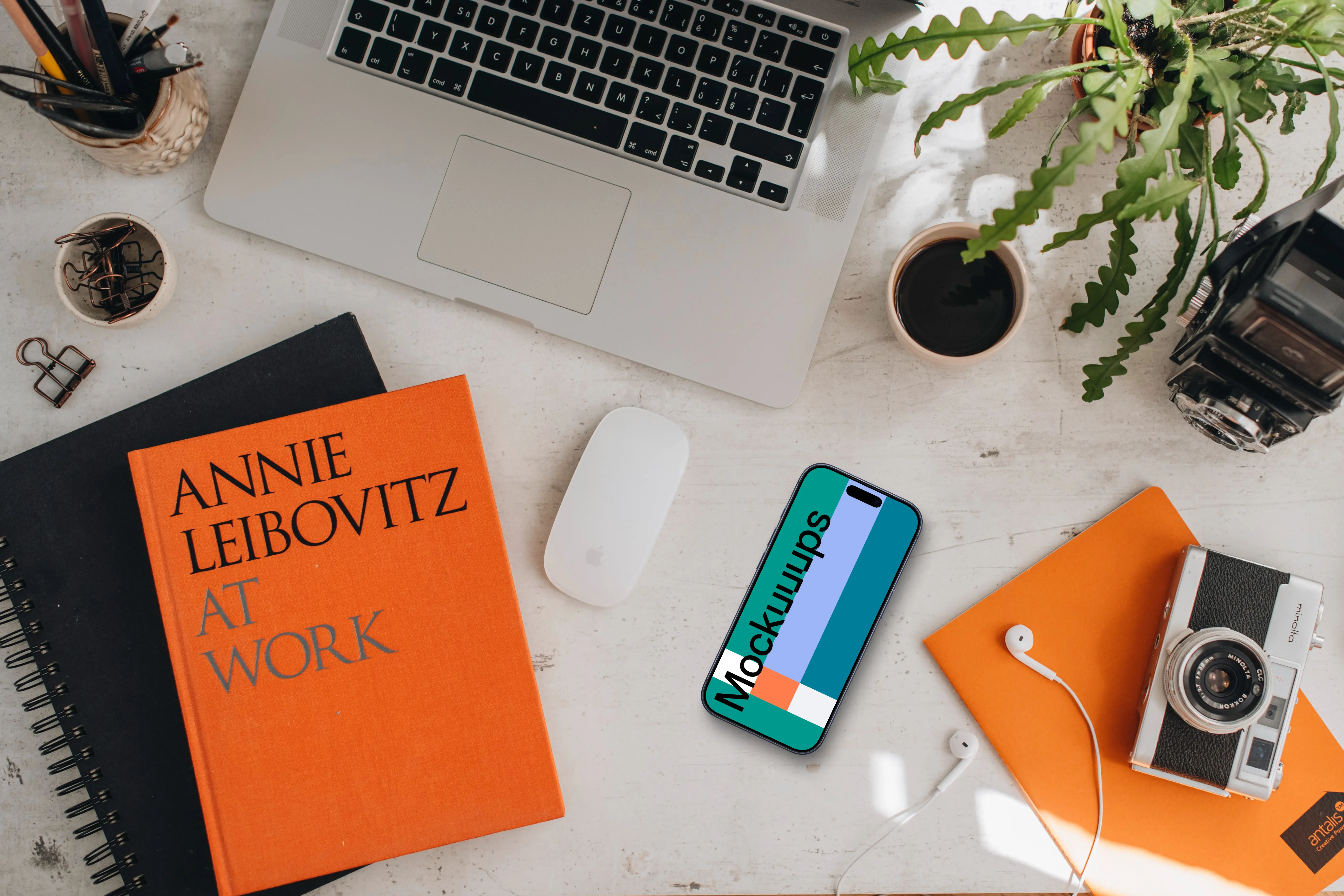 Mockup of smartphone device with books and MacBook Pro