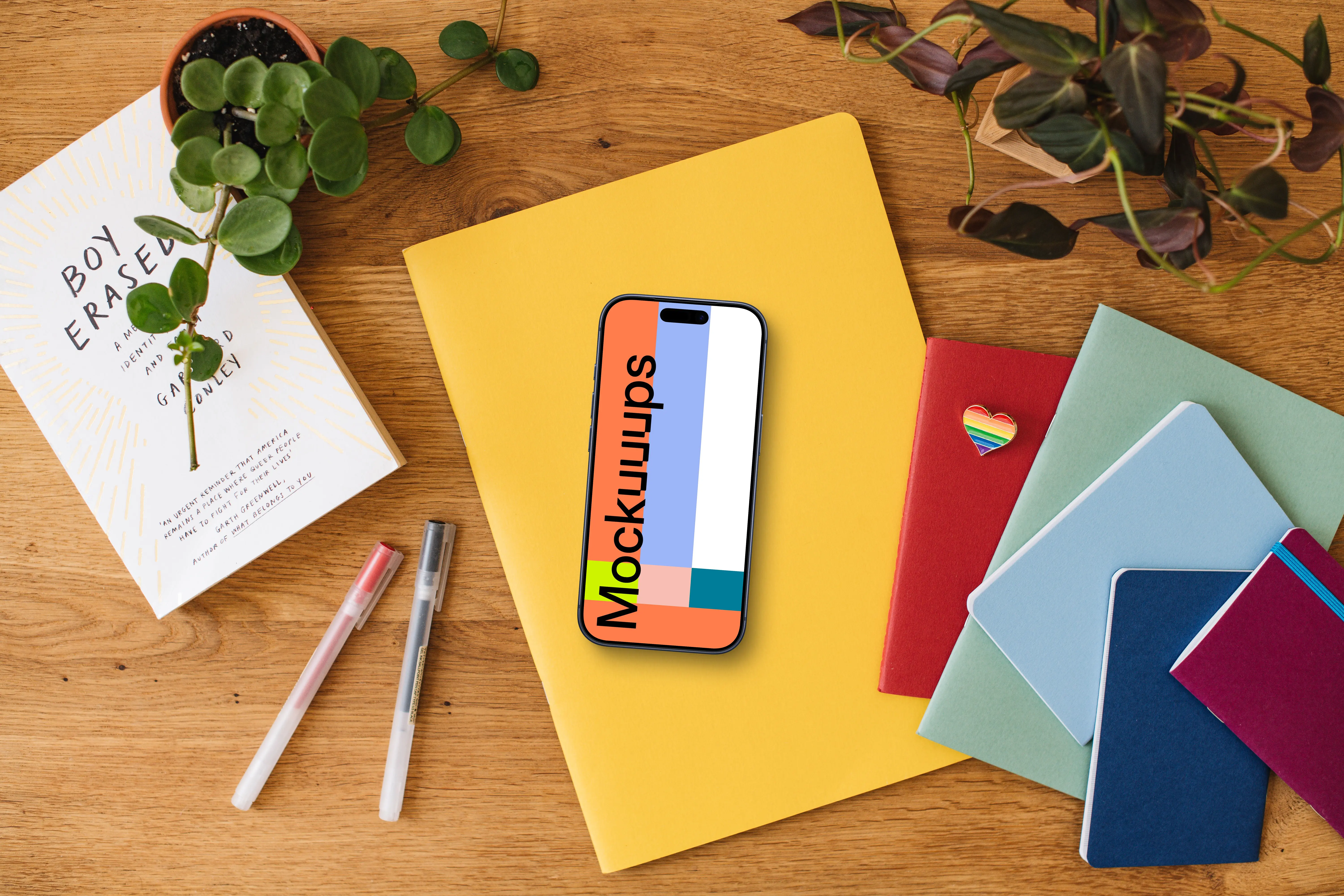 Smartphone mockup placed on colorful notebooks