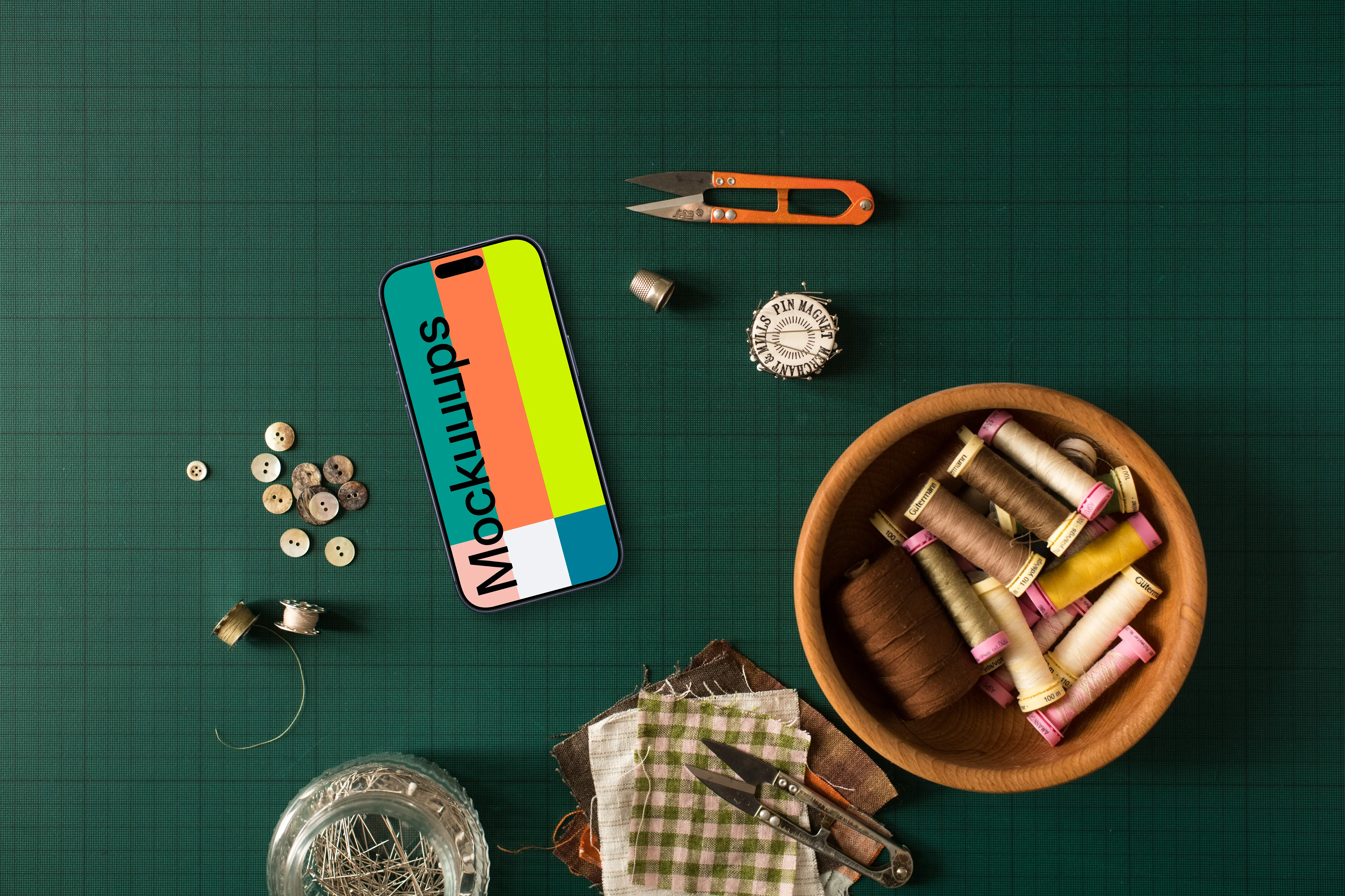 Smartphone mockup surrounded by sewing accessories