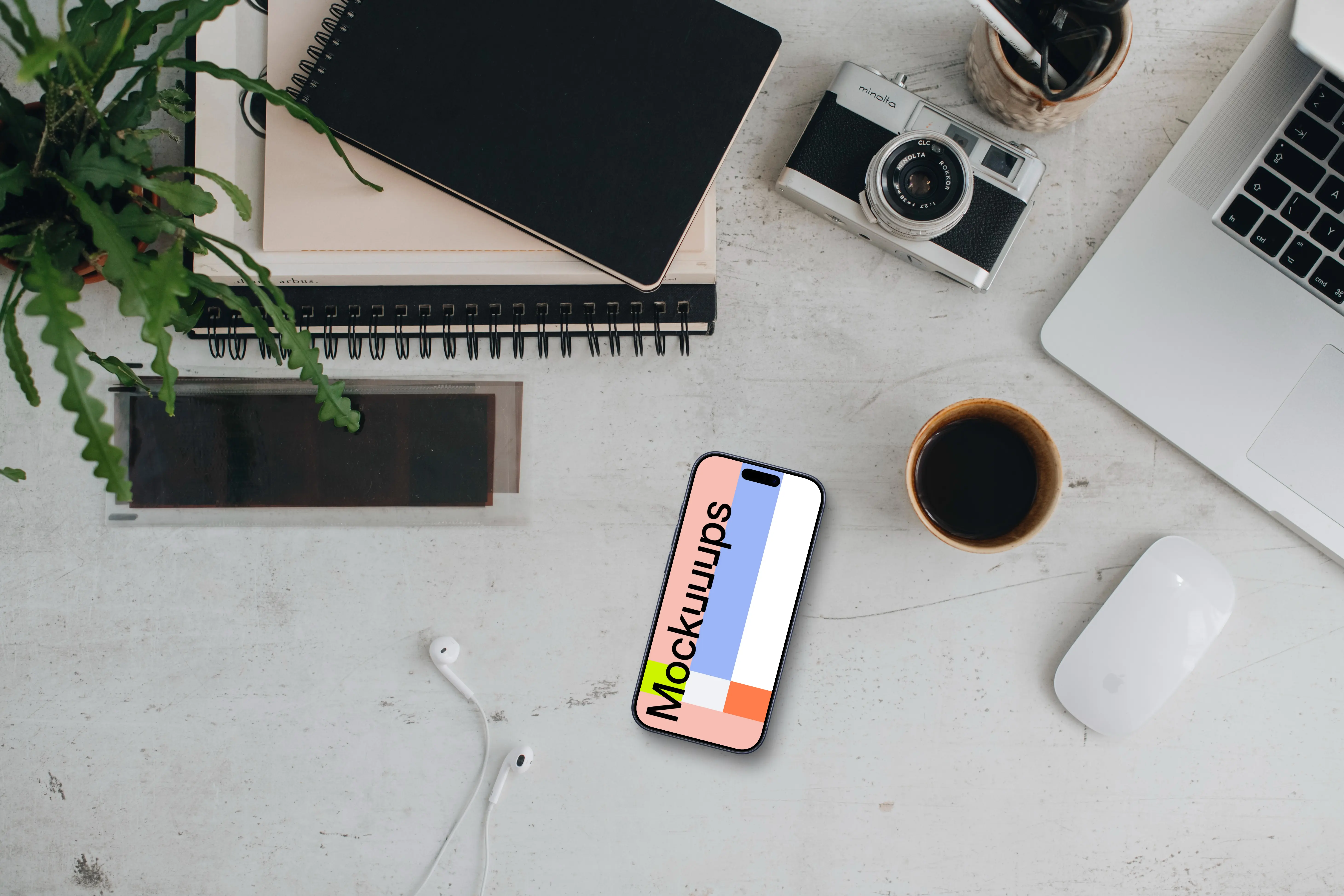 Smartphone mockup with headphones and MacBook Pro