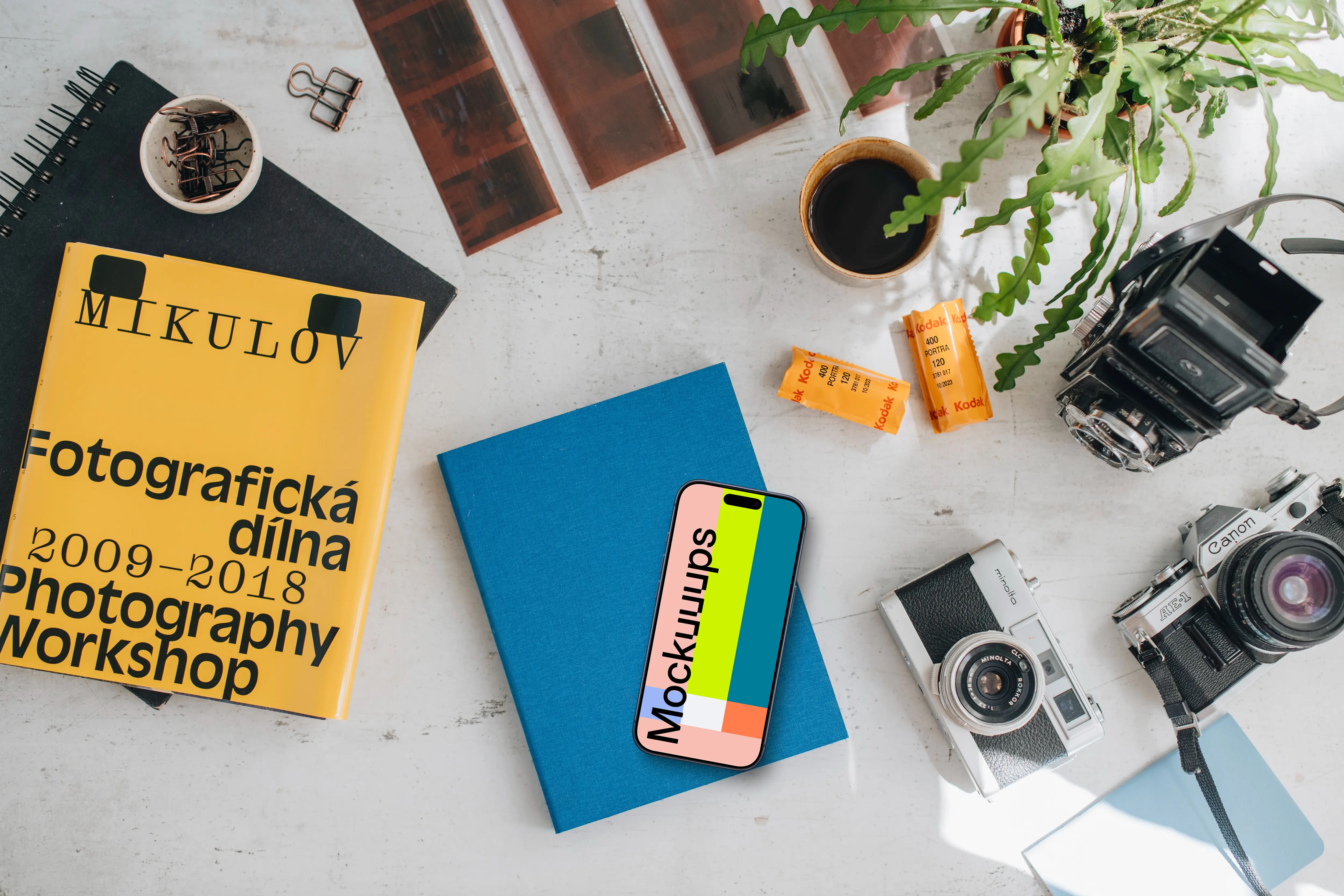 Top view of smartphone mockup with analog cameras and book