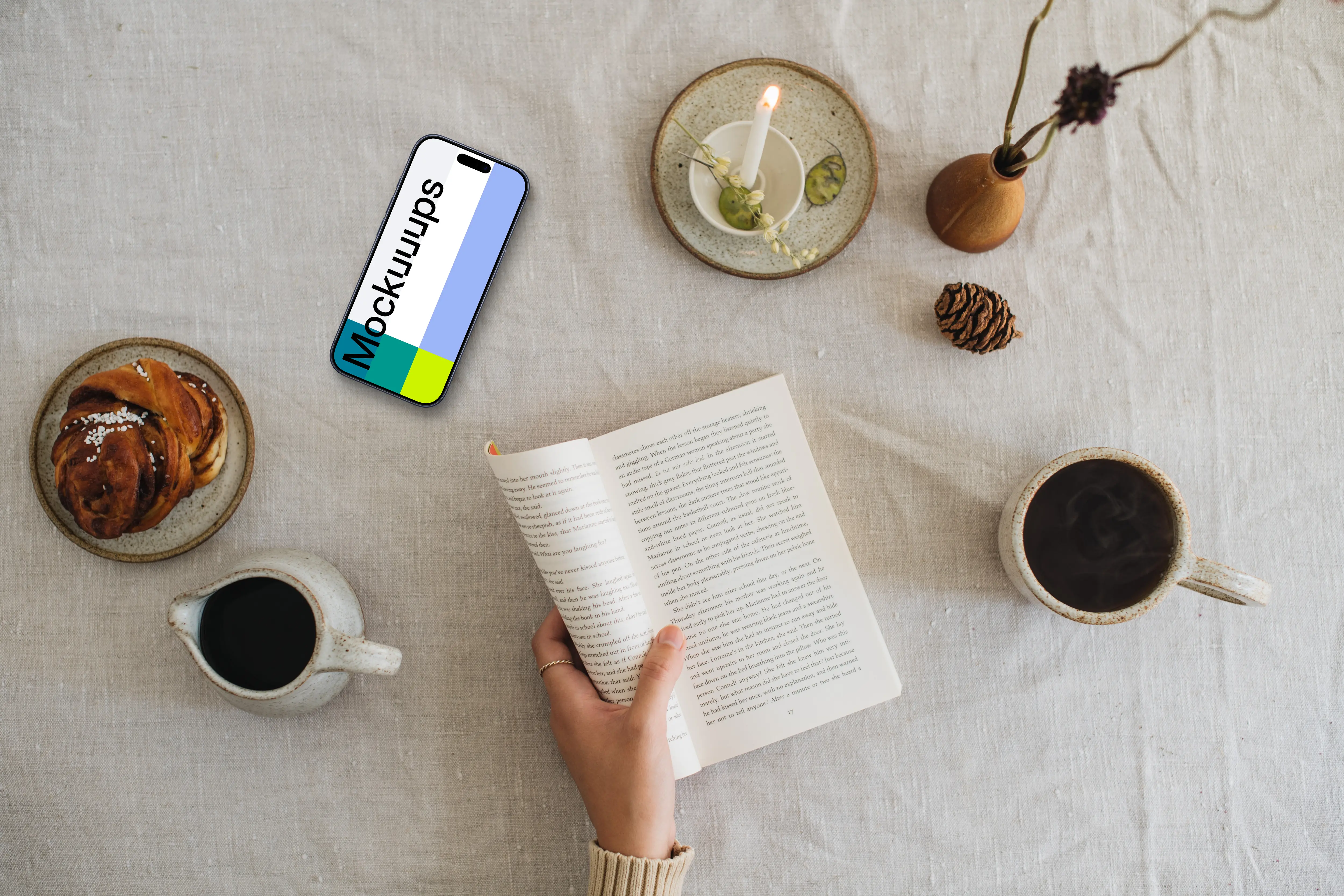 Top view of woman reading a book with smartphone on the side