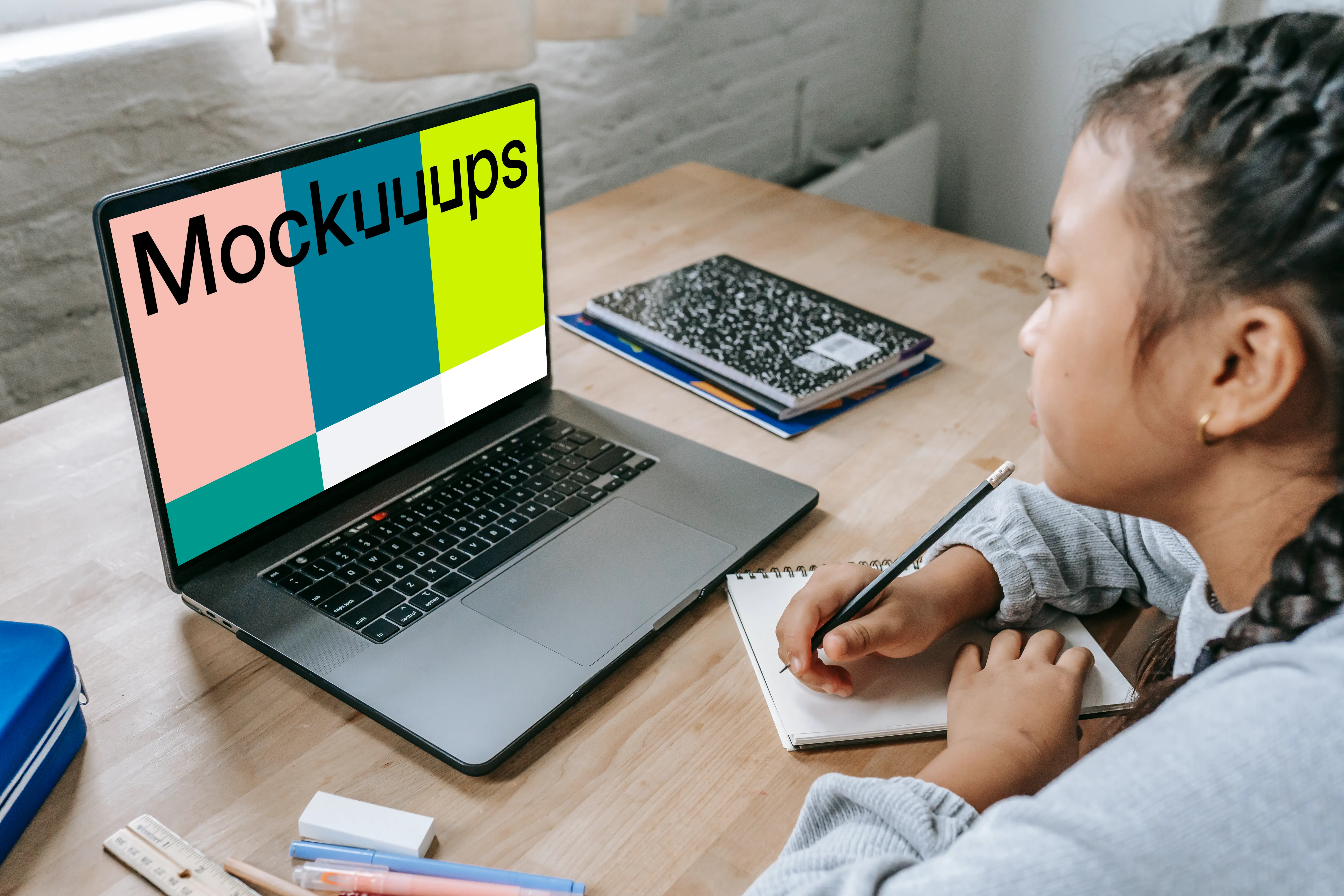 Young girl studying with a gray MacBook Pro mockup