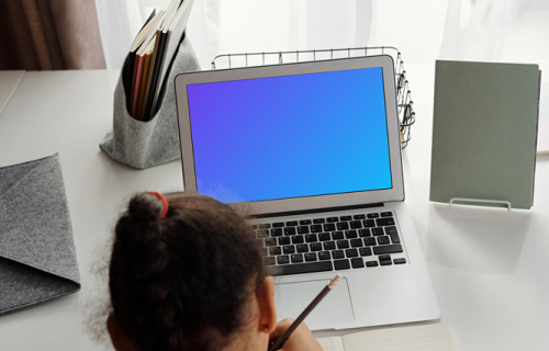Young girl with ponytail studying with her MacBook Air mockup