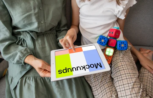 Adult showing a kid something on an iPad mockup