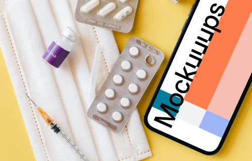 iPhone 12 Pro mockup on a table beside some medicines