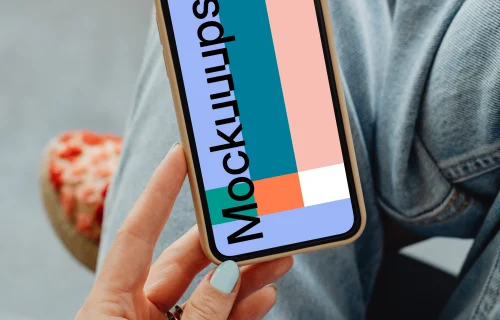 iPhone mockup hand held by user above her laps