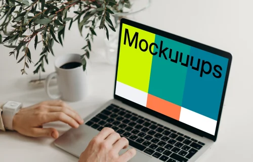 MacBook Pro mockup on a table with reading glasses by the side