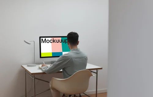 Man working on his iMac with his back to the camera