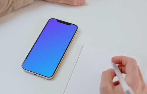 Simple iPhone mockup on a white table beside a book