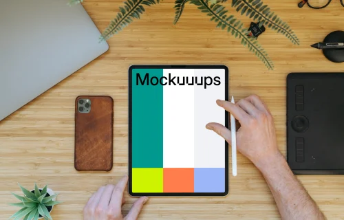 Tablet mockup on a wooden table with iPhone 11 at the side