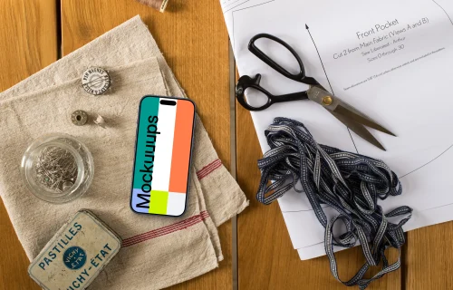 Top view of smartphone with sewing accessories