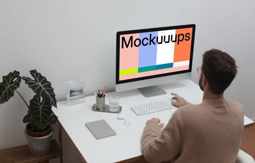 User using an iMac at his workstation
