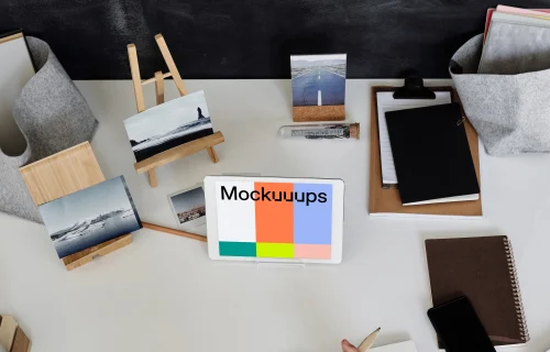 Young boy using an iPad mini on a table with a jotter by the side mockup