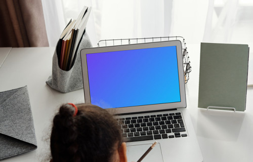 Young girl with ponytail studying with her MacBook Air mockup