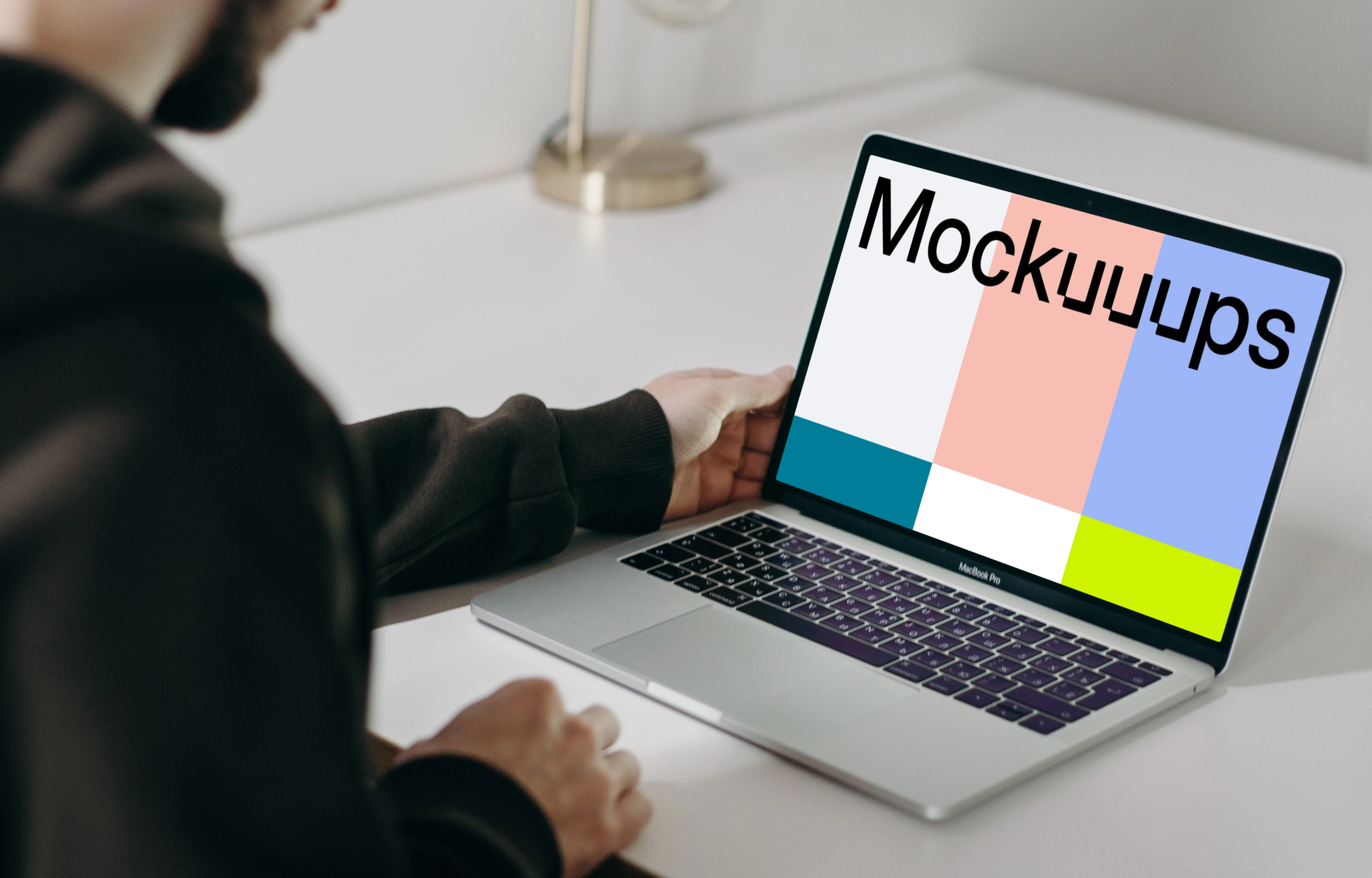 MacBook Pro mockup on a white table facing a mirror