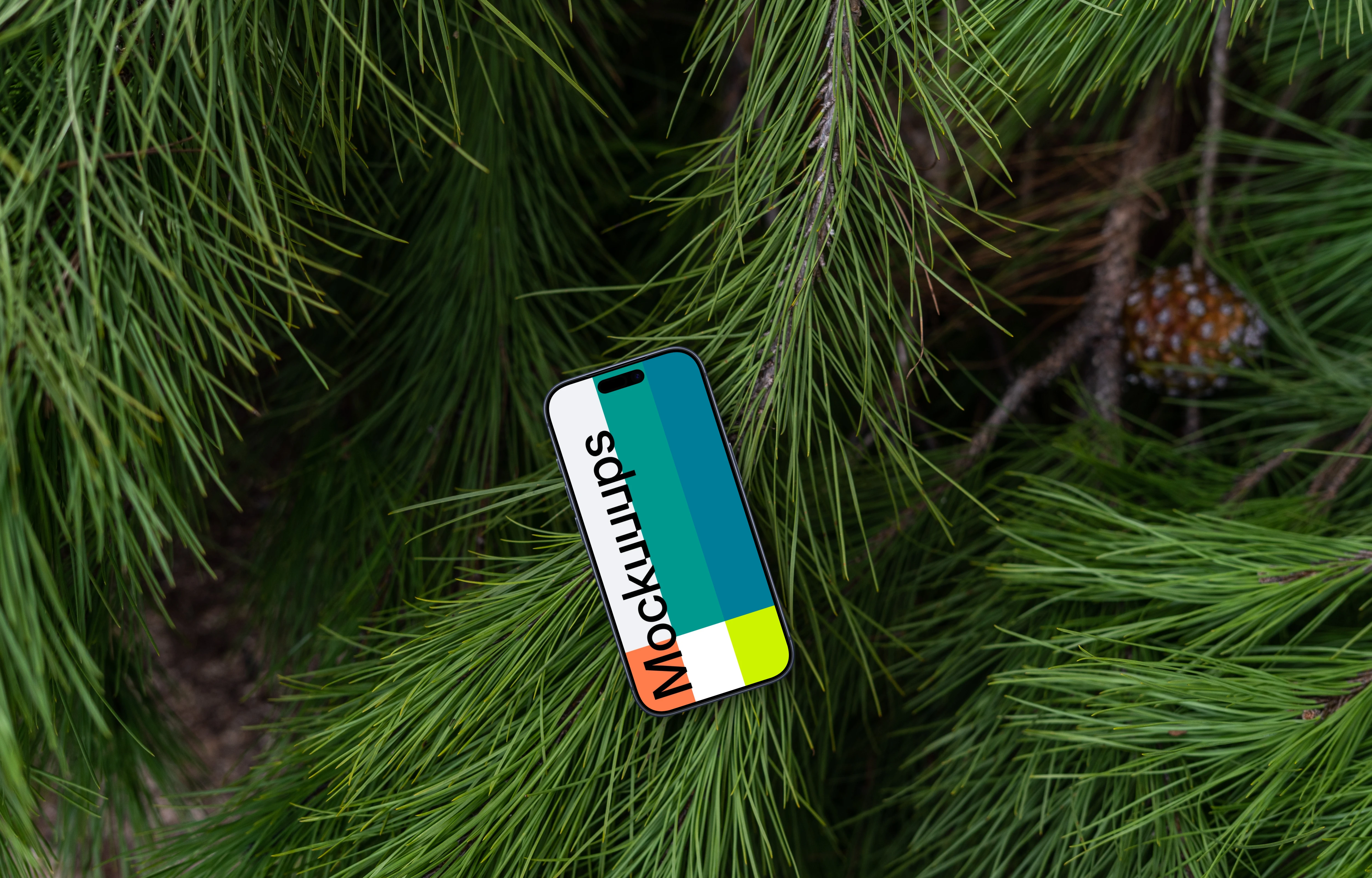 A smartphone mockup laying on top of a pine tree