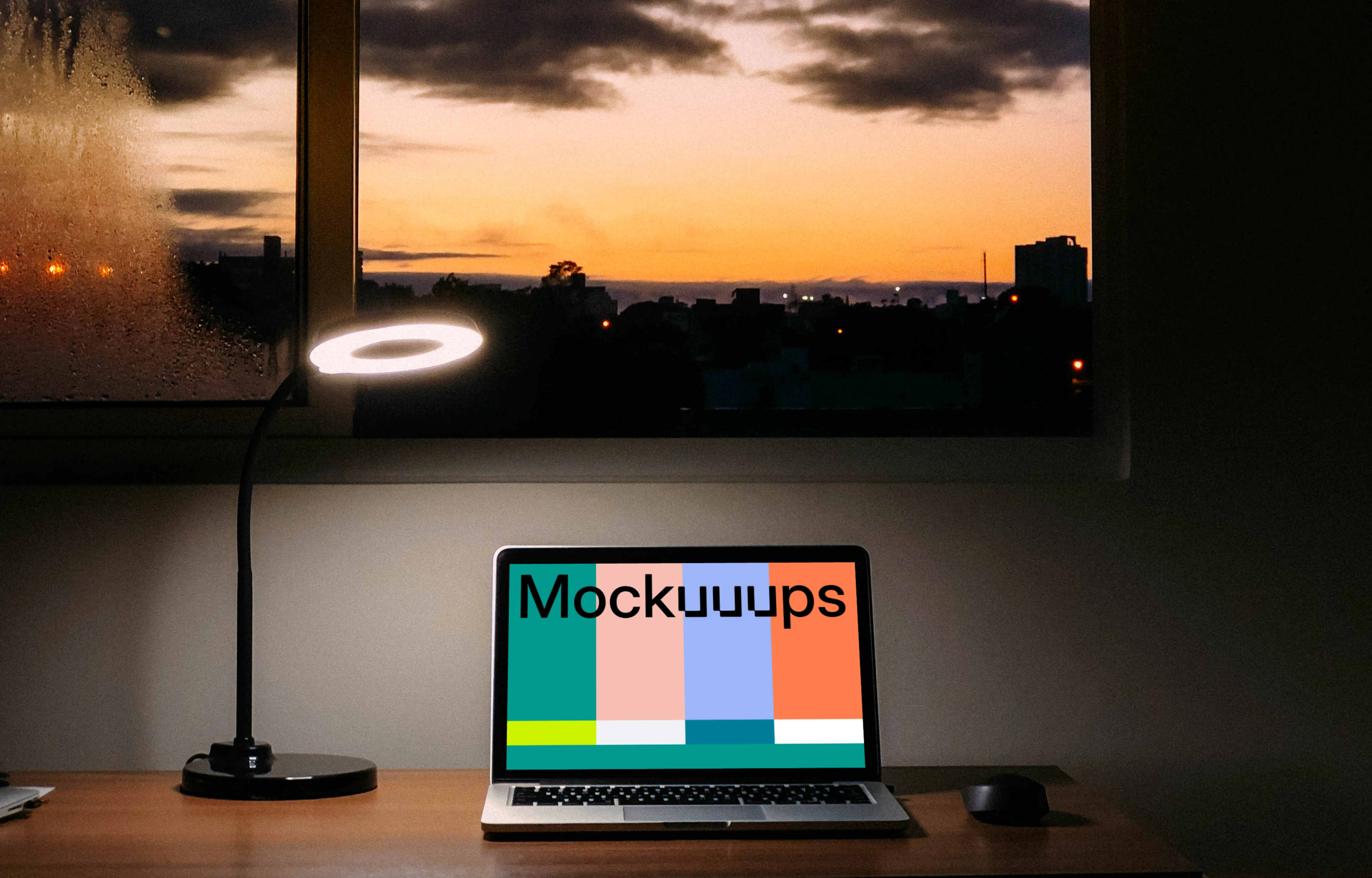 MacBook mockup at night with a reading lamp shining over it