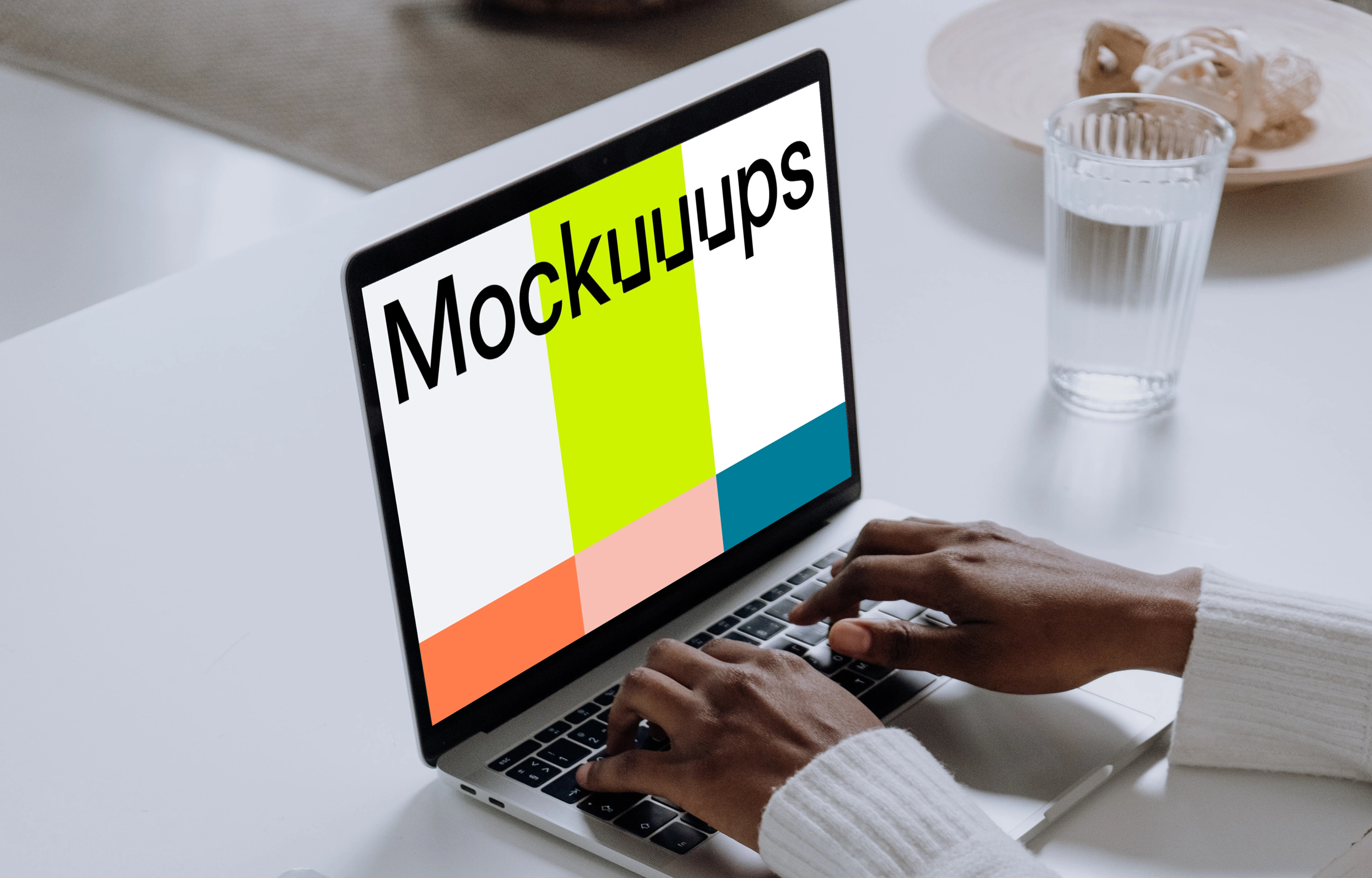 MacBook Pro Mockup on a white table with a notebook and cup of water