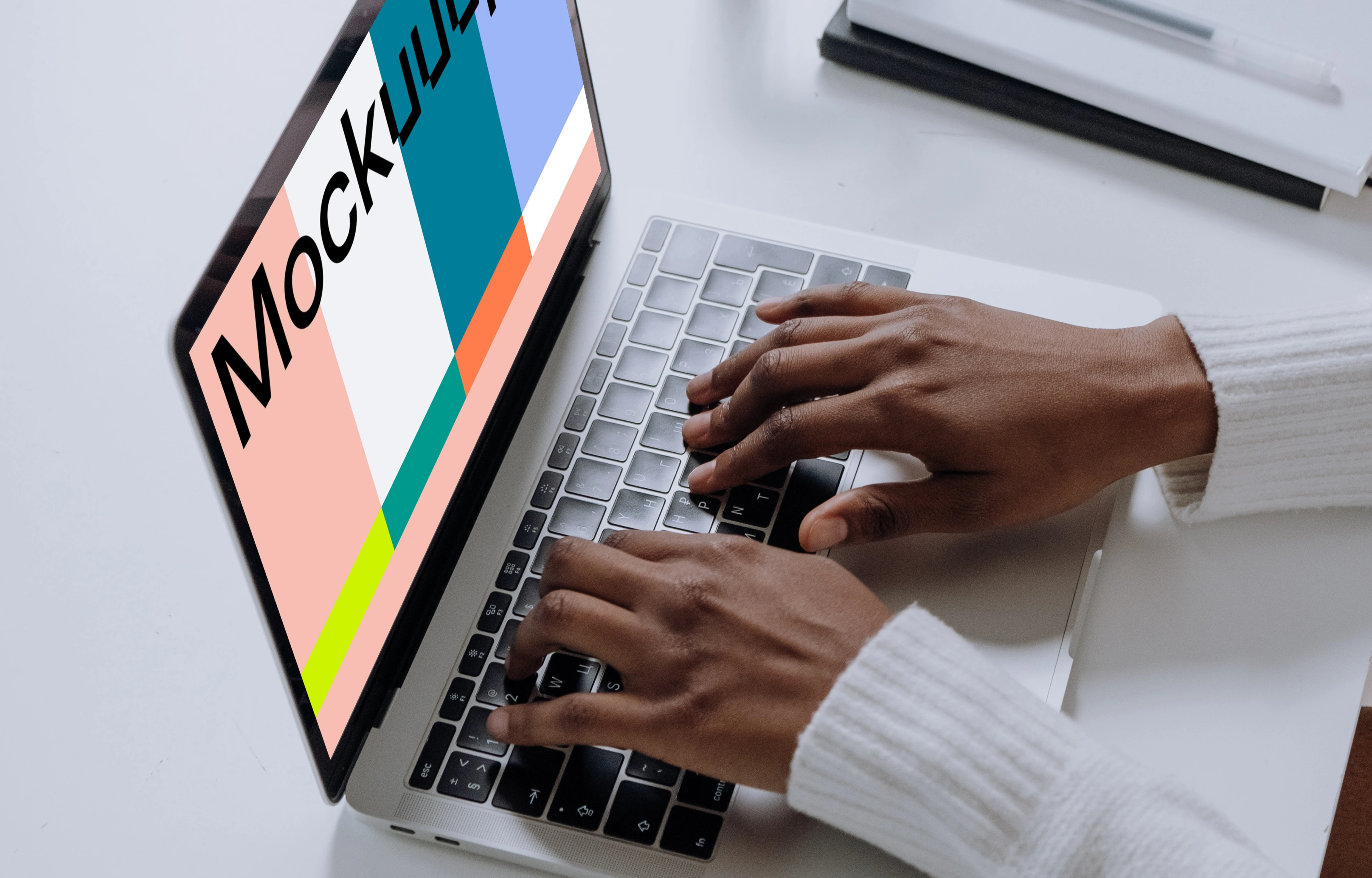 MacBook Pro mockup on a white table with glass of water at the side