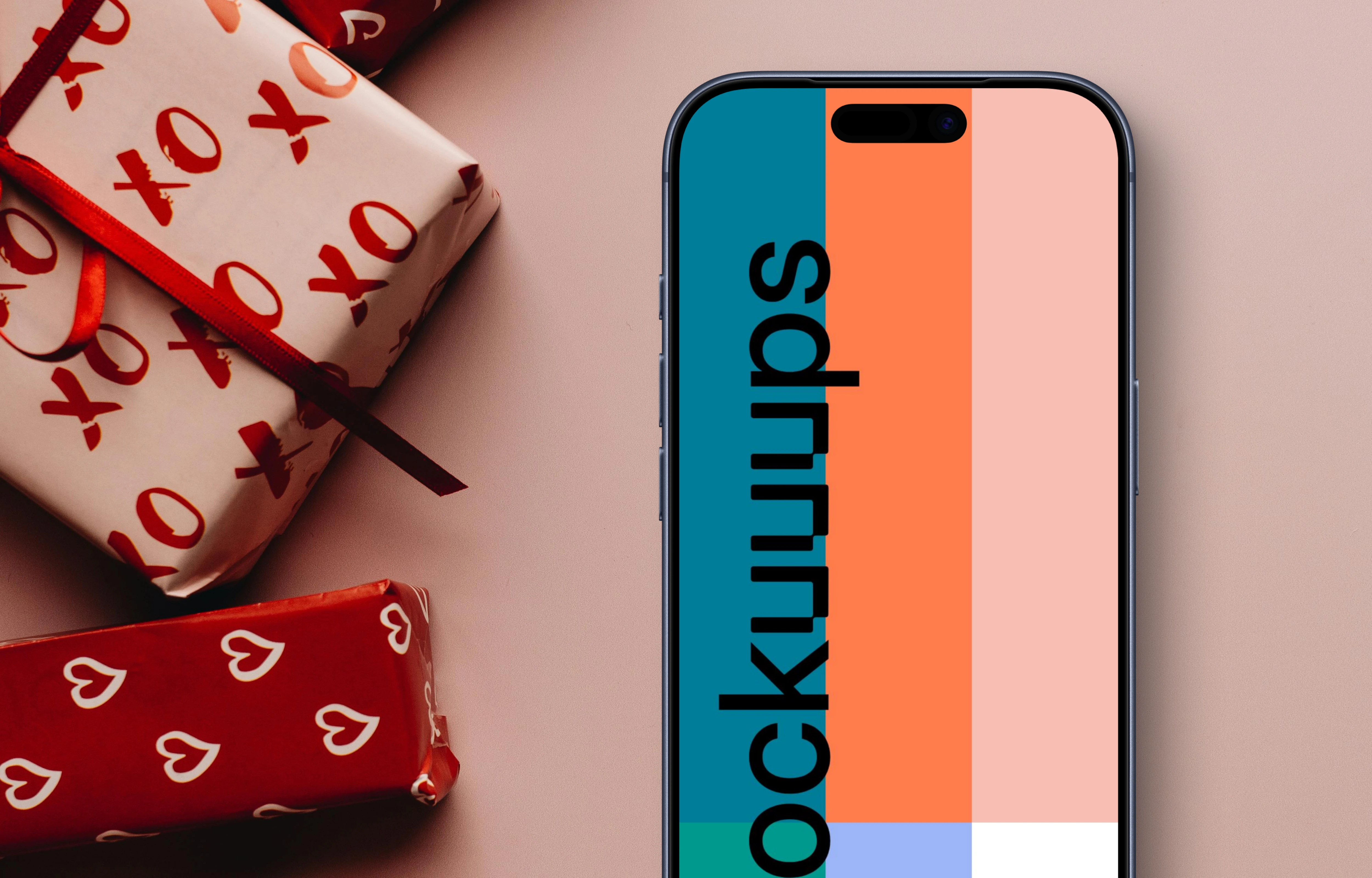 Smartphone mockup next to wrapped romantic gifts