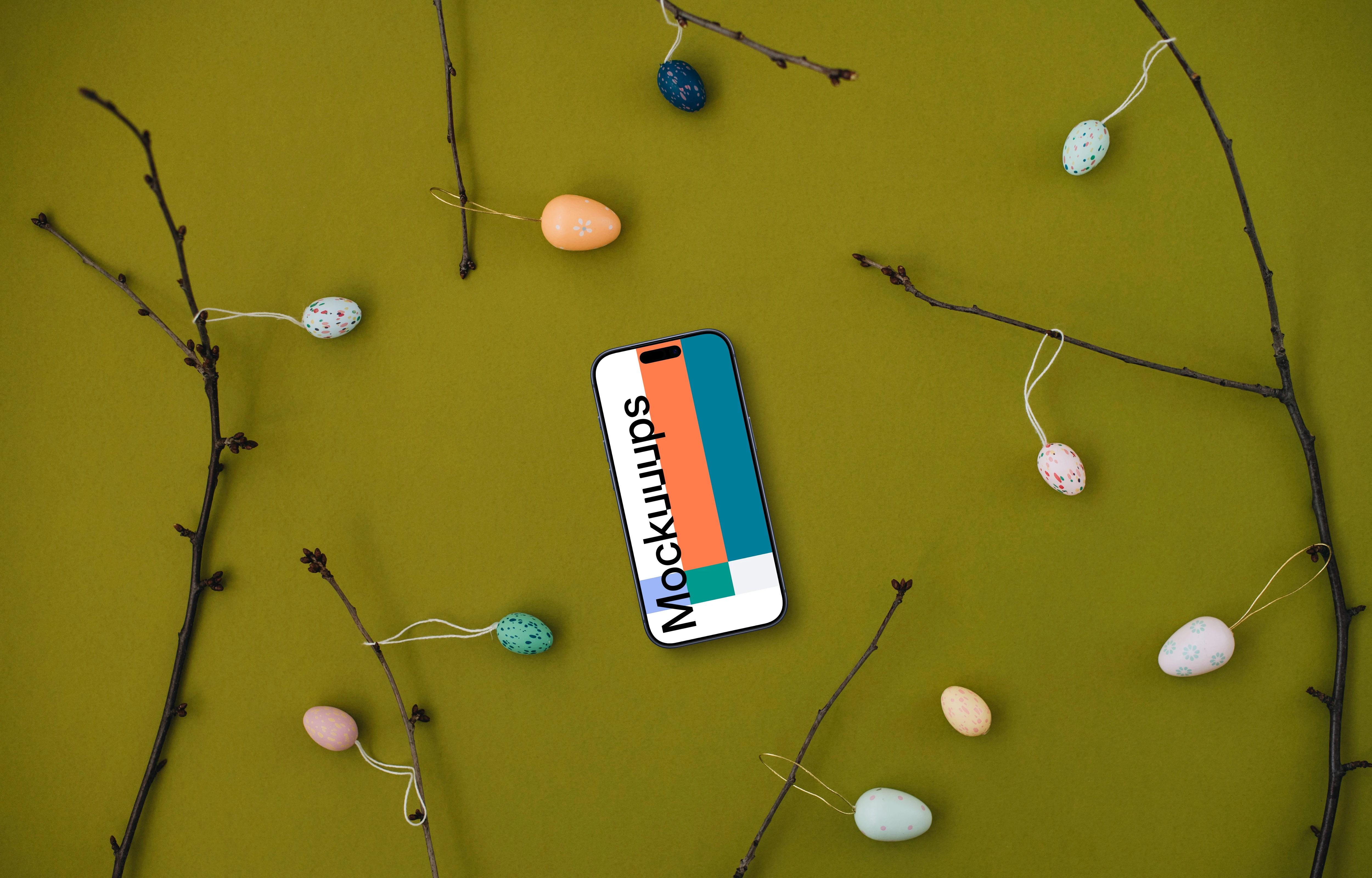 Smartphone mockup among spring branches with decorated eggs