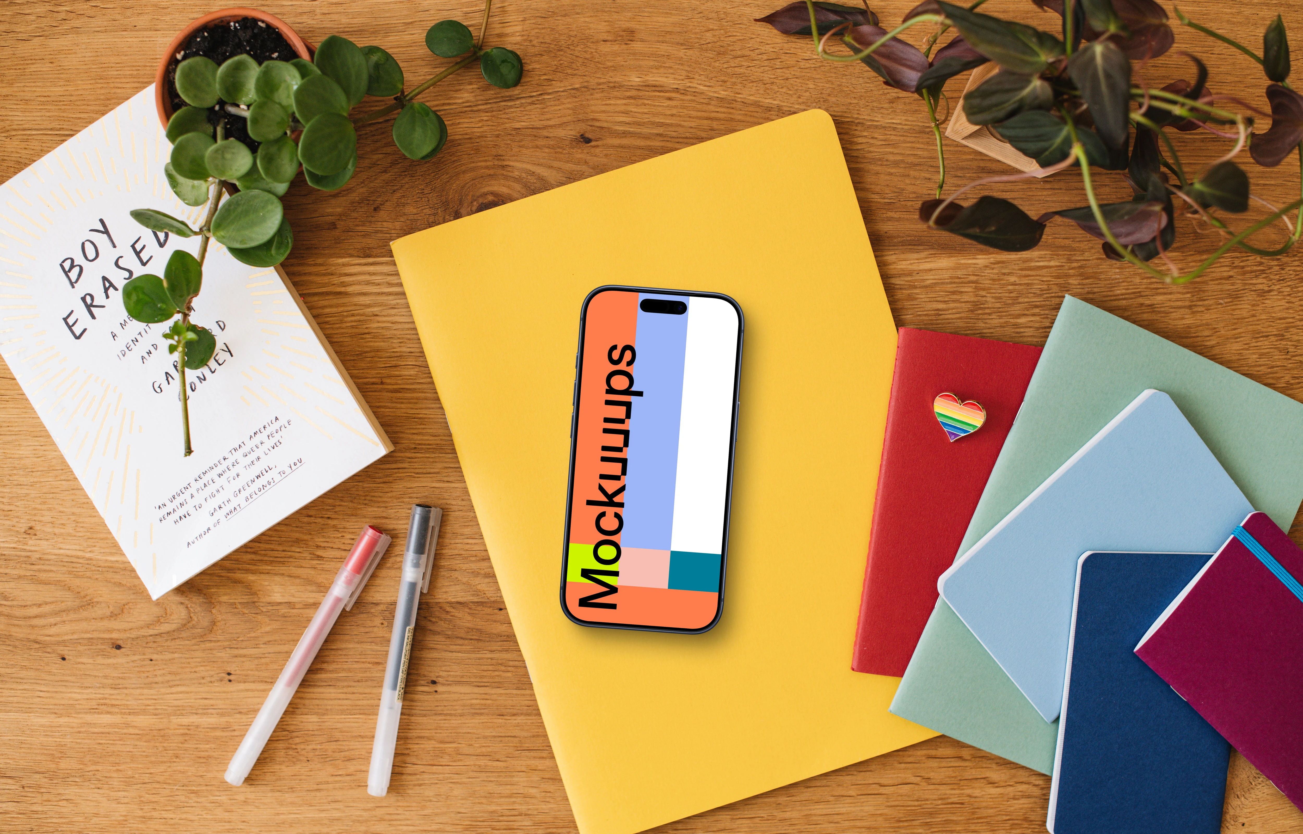 Smartphone mockup placed on colorful notebooks