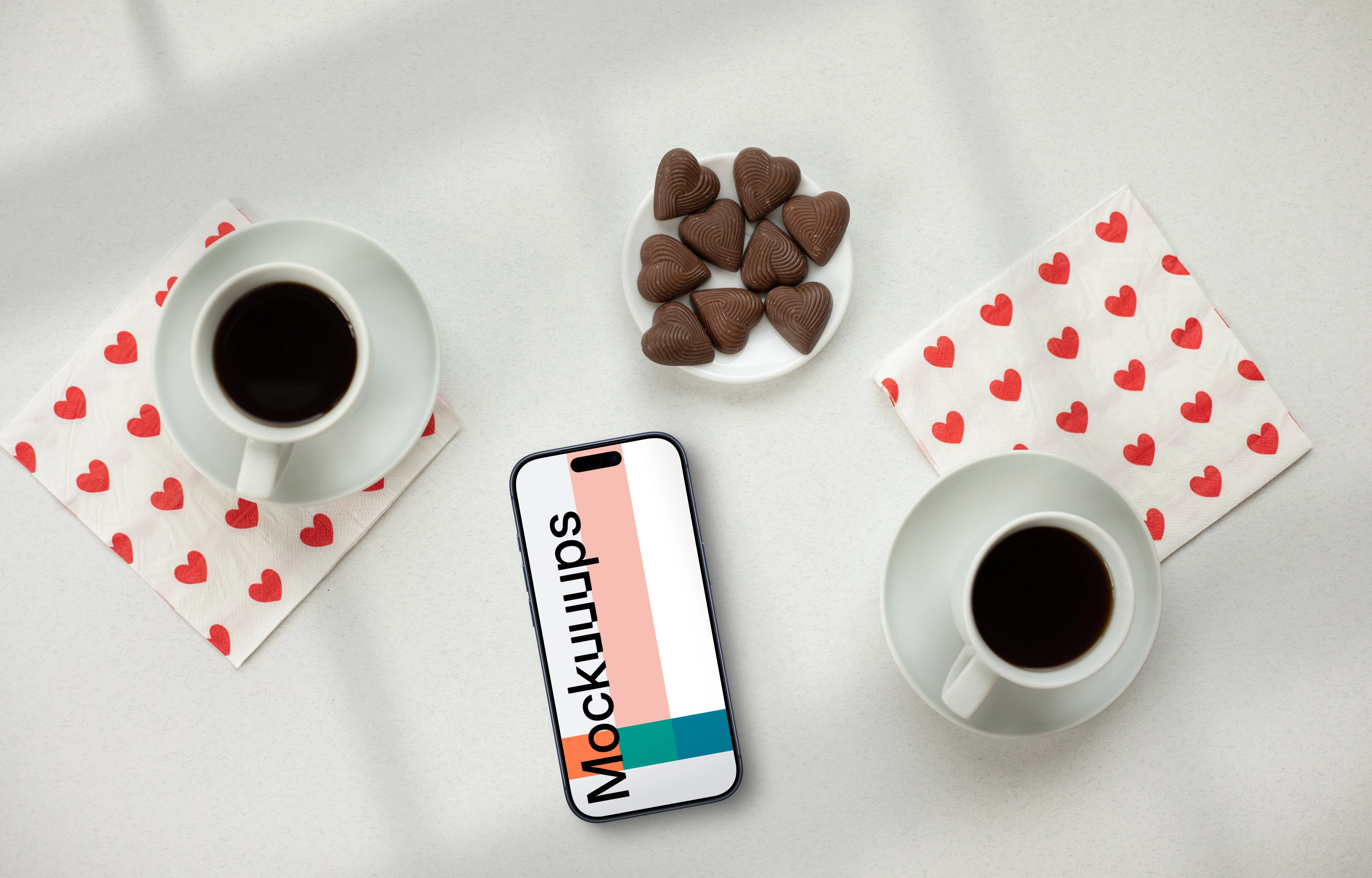 Smartphone mockup with two coffees and heart-shaped chocolates