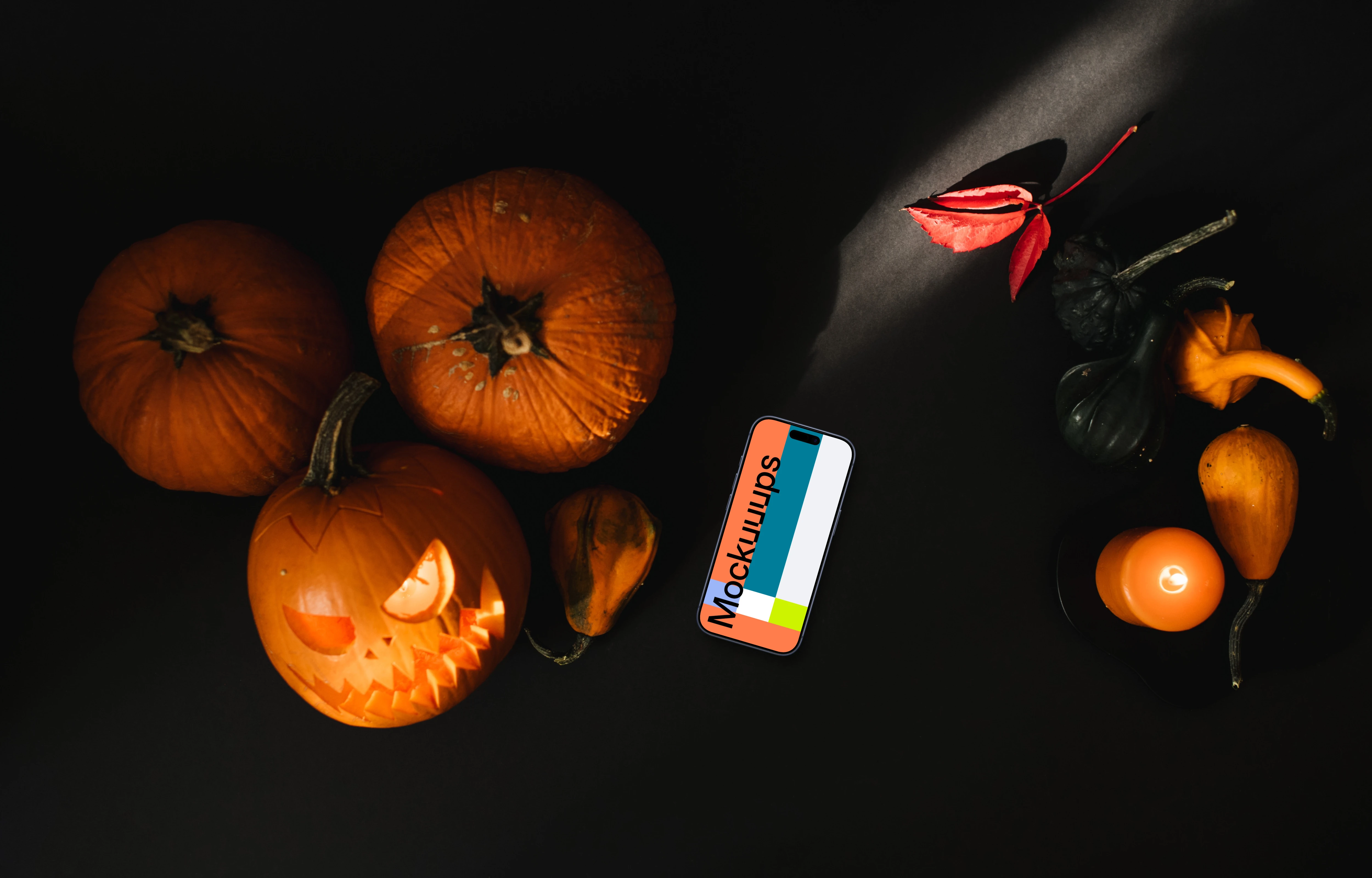 Halloween pumpkin mockup with a smartphone and candles