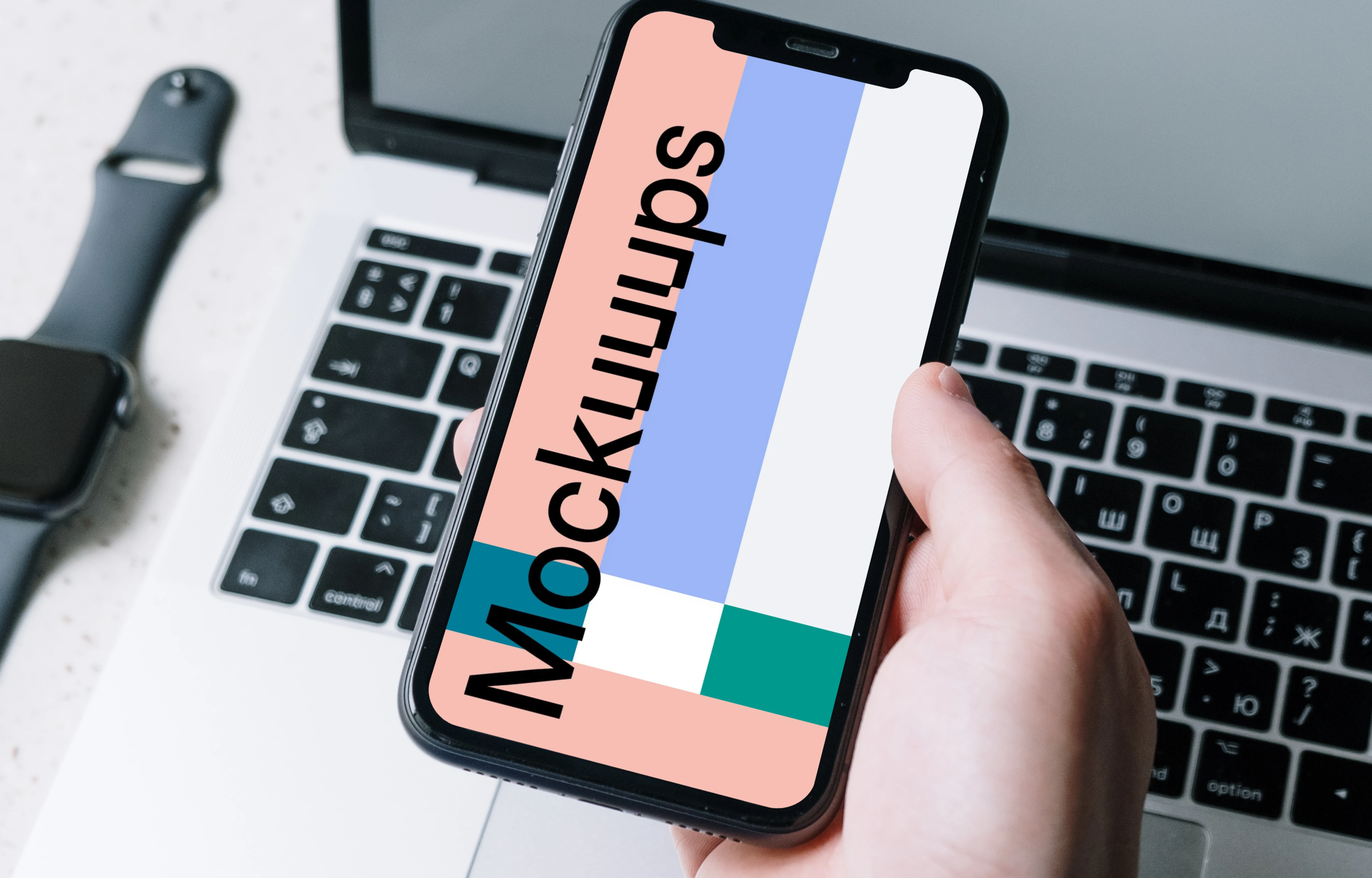 iPhone mockup held above a MacBook by a user in corporate dressing