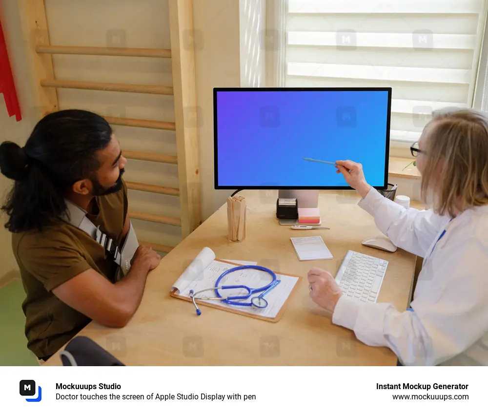 Doctor touches the screen of Apple Studio Display with pen 