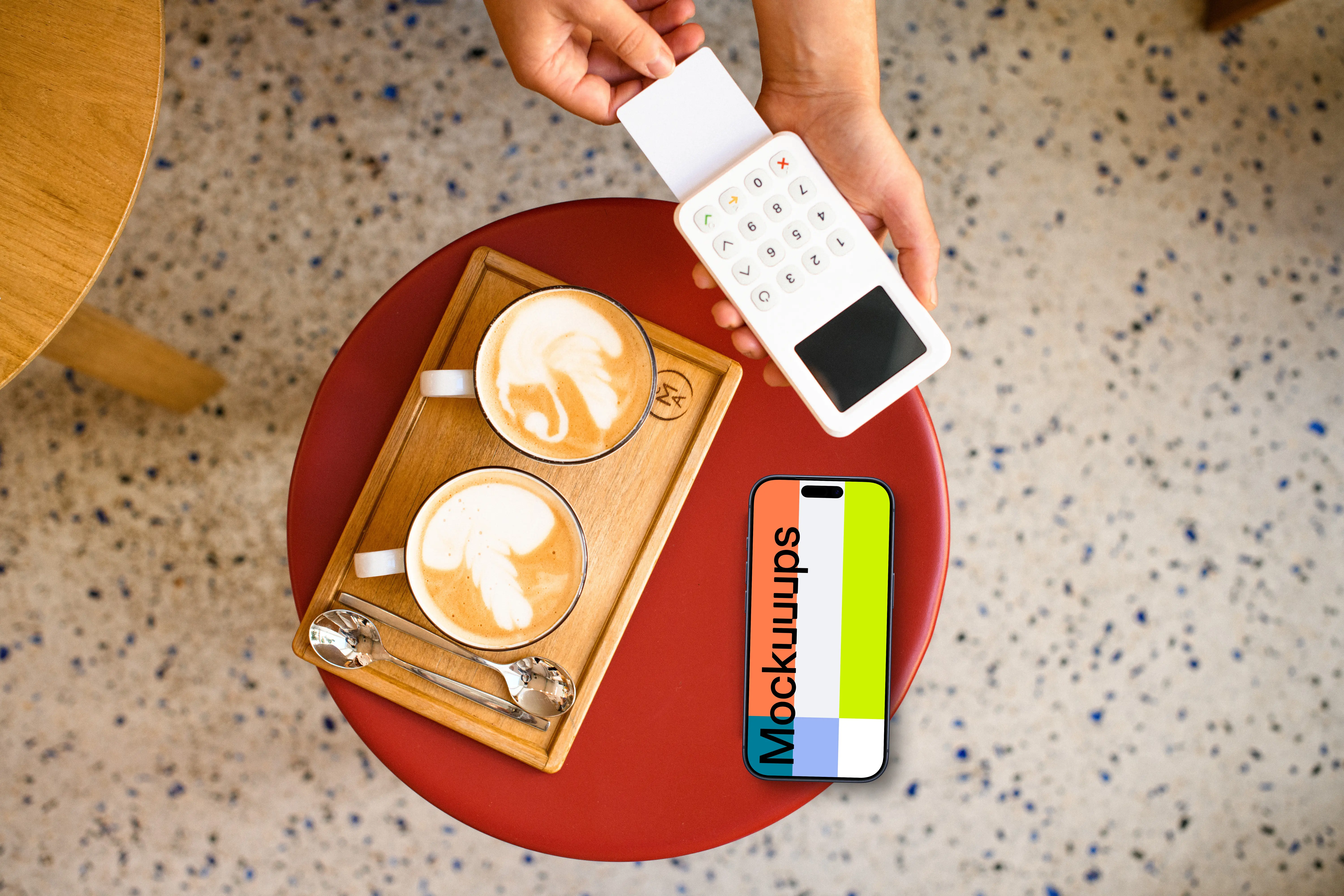 Cozy cafe setting with payment terminal and an iPhone mockup