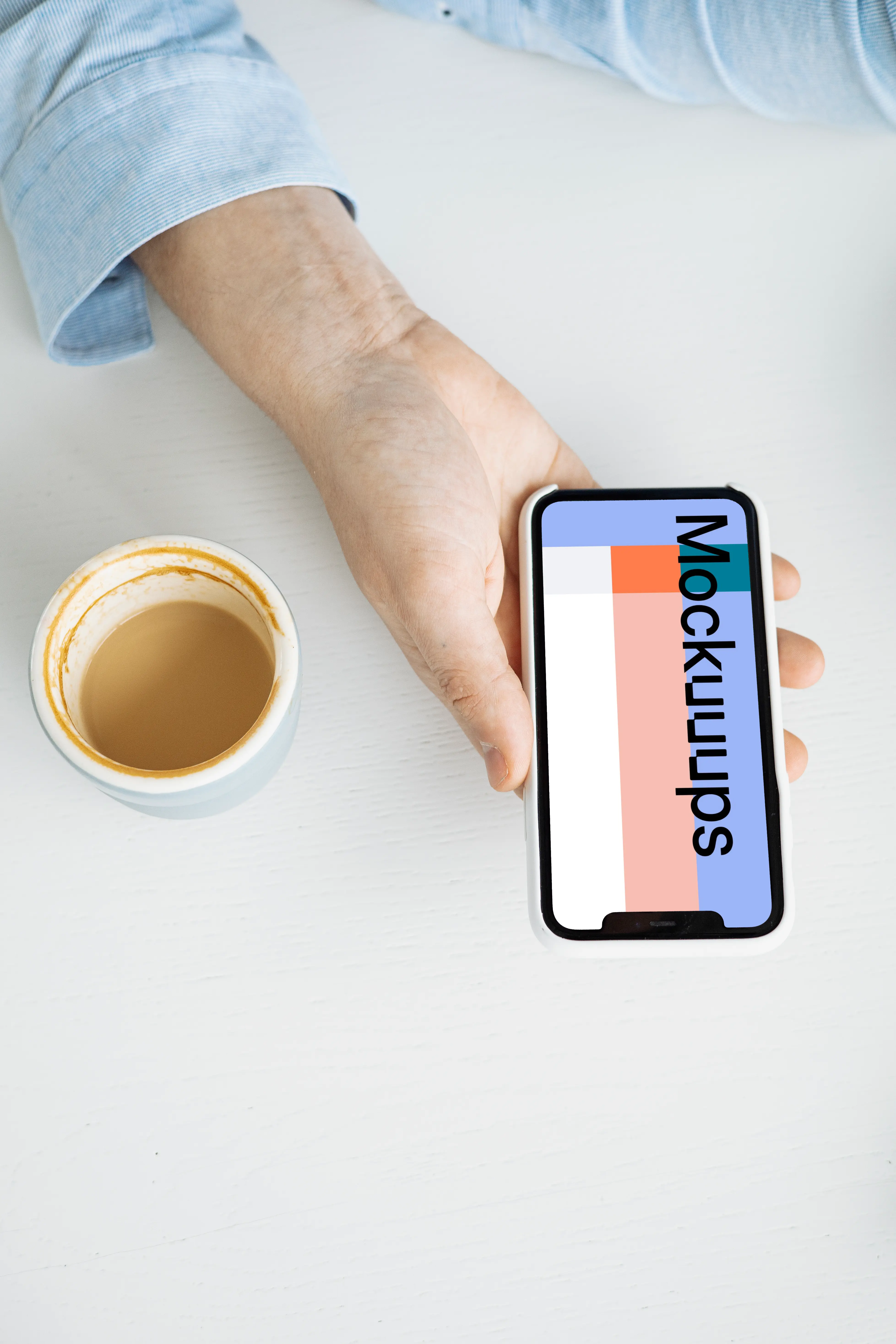 iPhone mockup in a user’s hand with a cup of coffee at the side