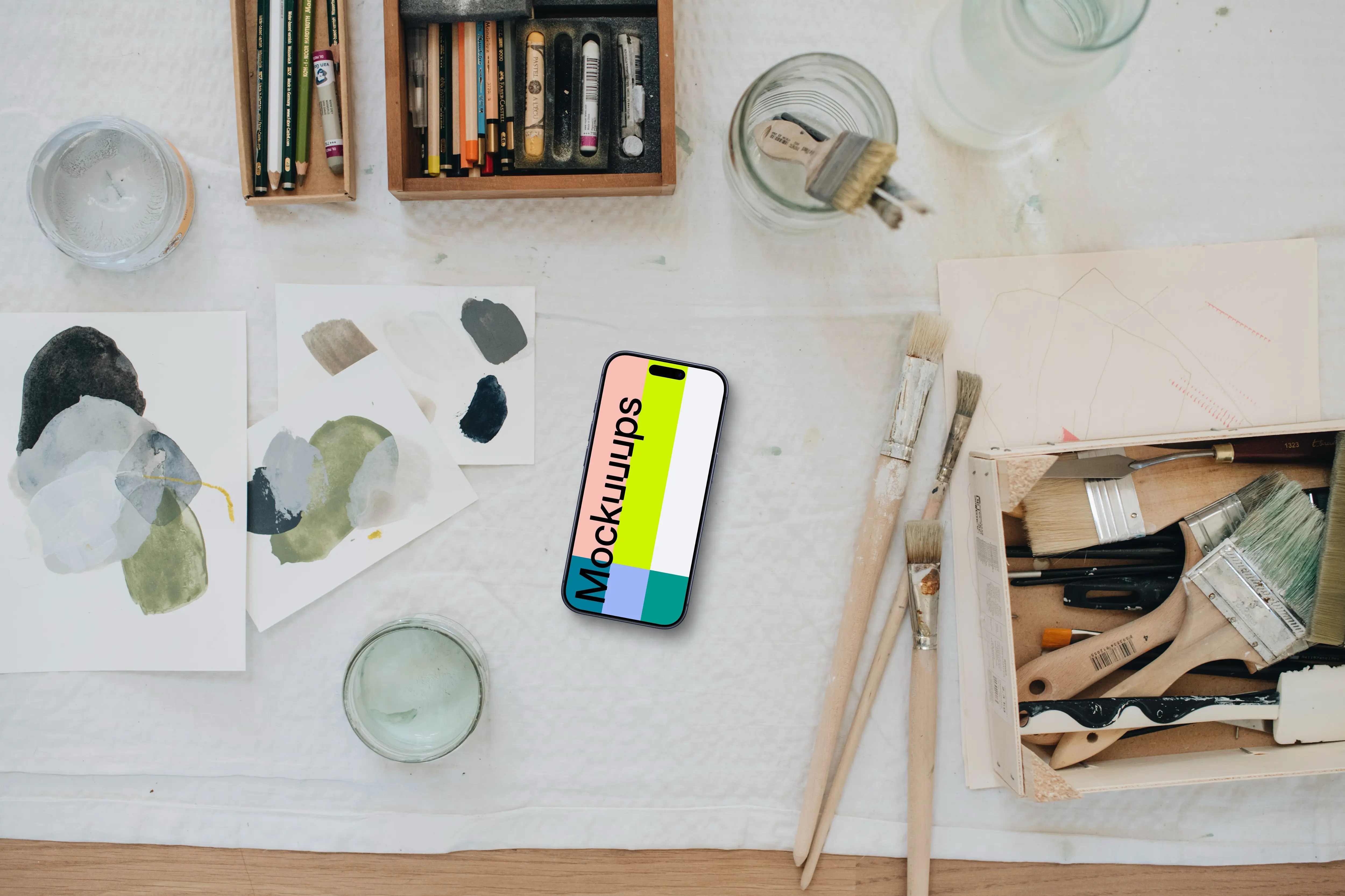 iPhone mockup surrounded by artistic tools