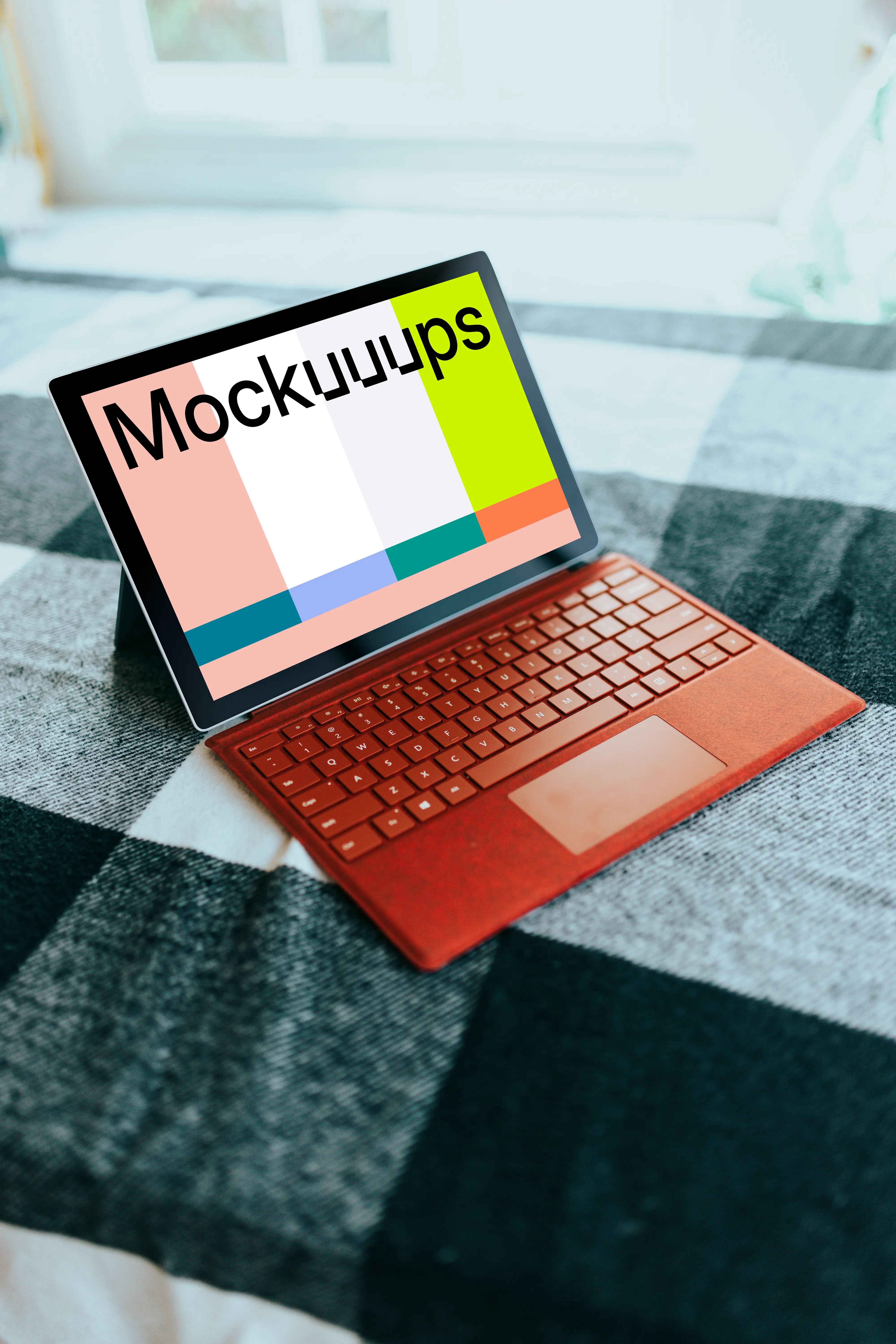 Red Microsoft Surface Laptop mockup on a bed