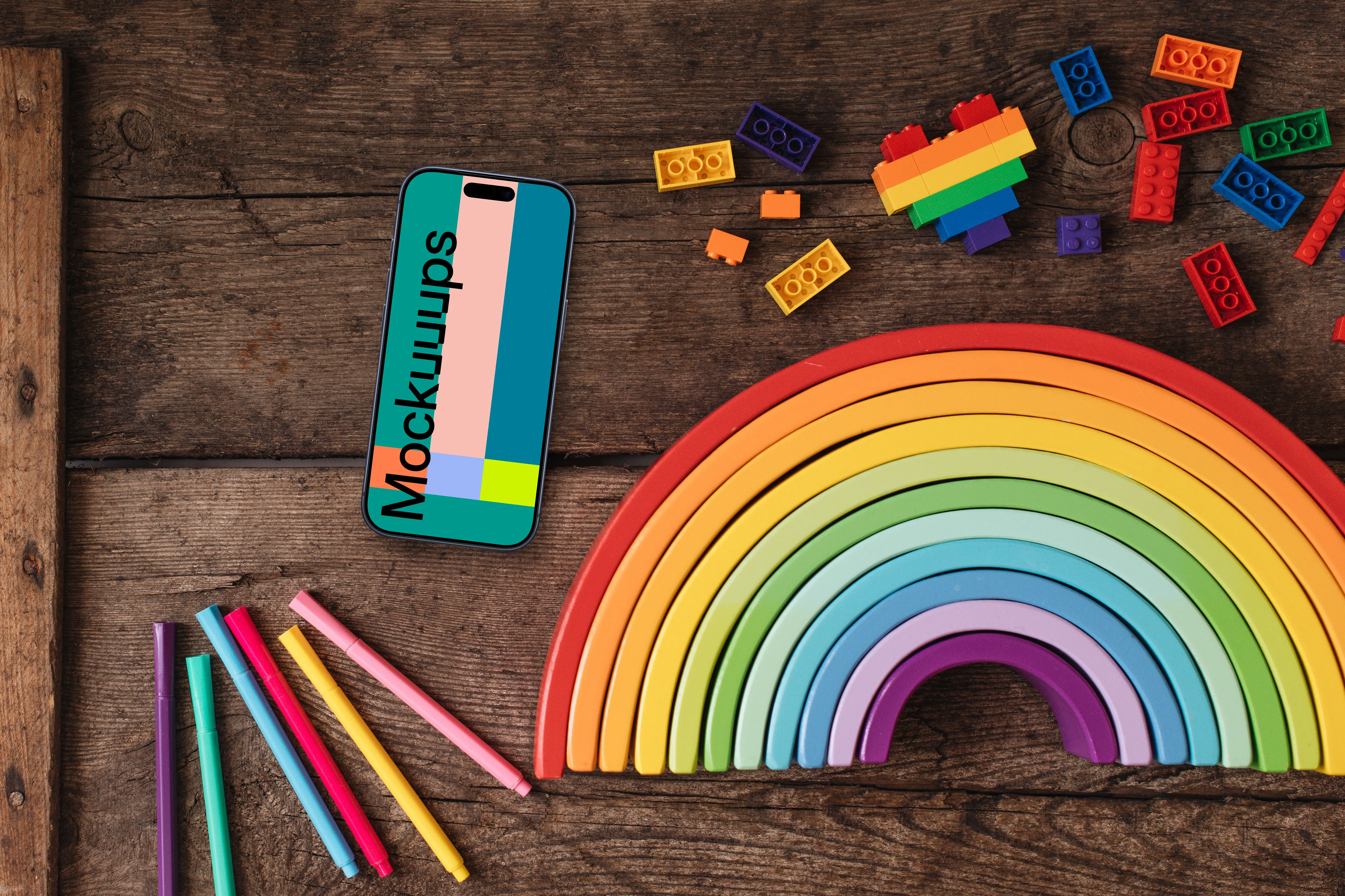 Smartphone mockup on a wooden table with rainbow items