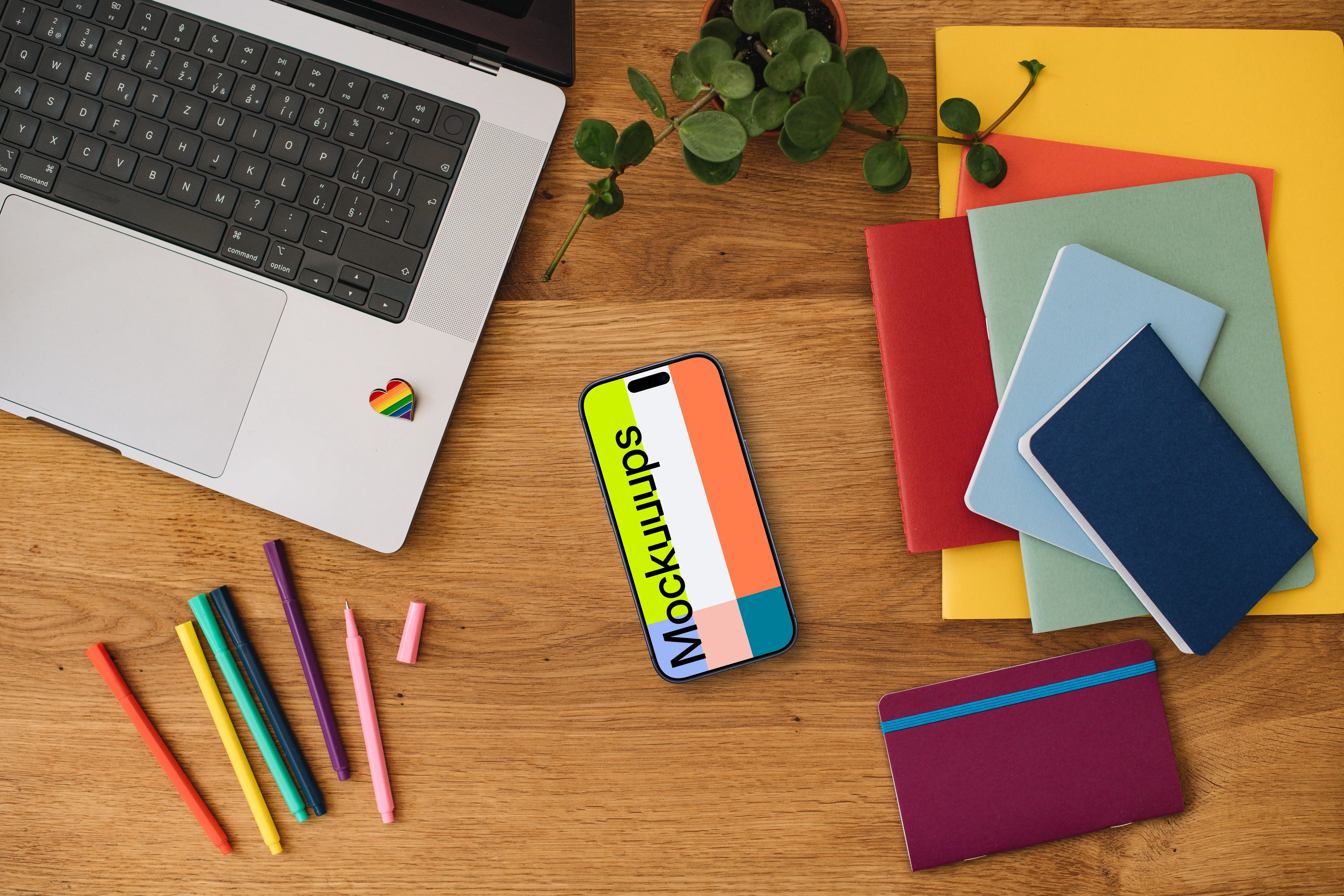 Smartphone mockup with rainbow pens and notebooks