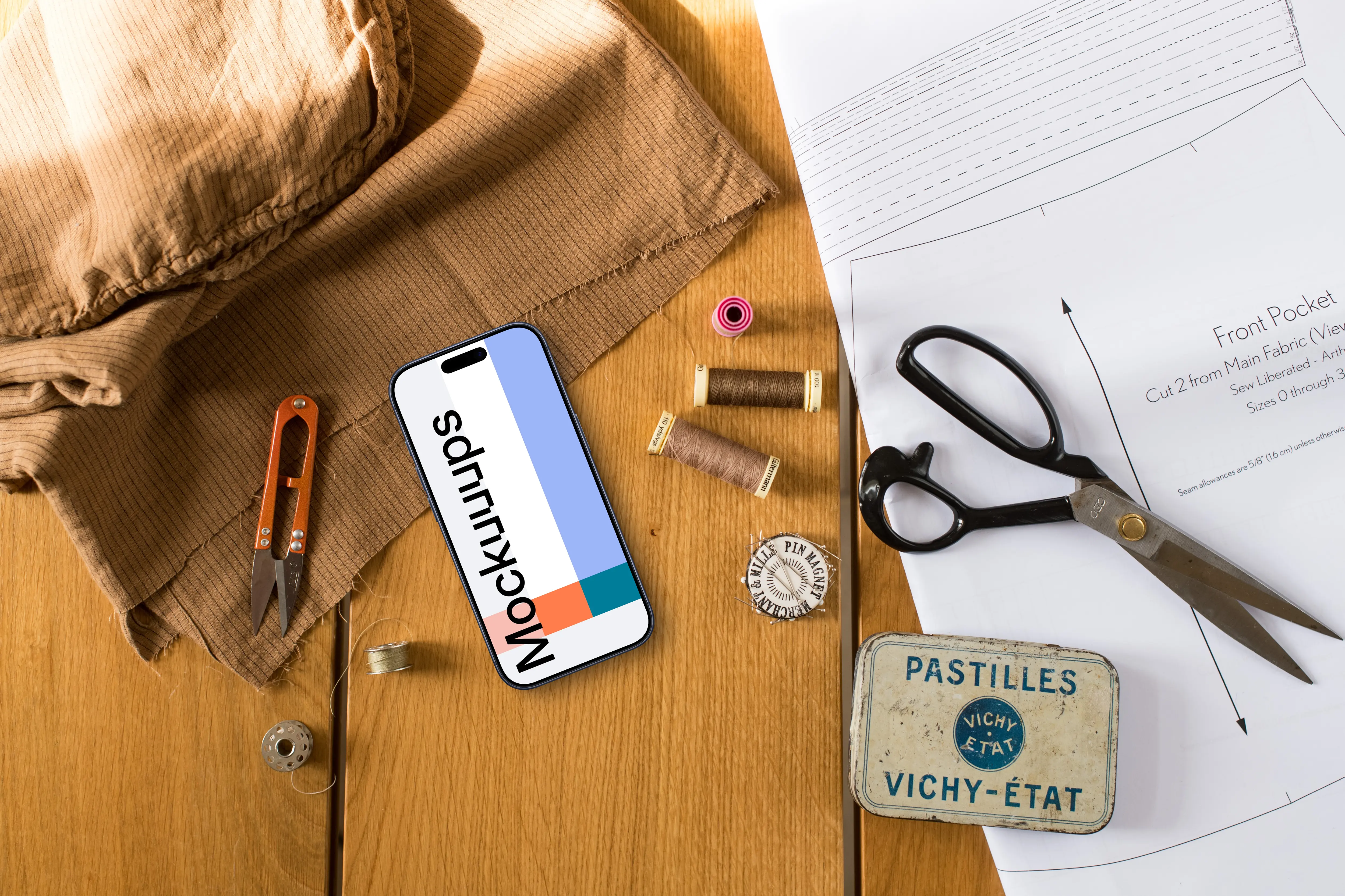 Top view of smartphone mockup with a sewing scissors