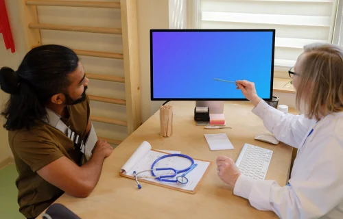 Doctor touches the screen of Apple Studio Display with pen