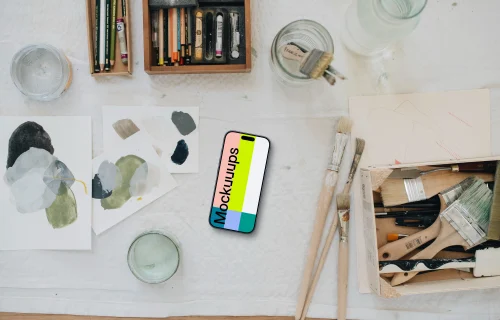 iPhone mockup surrounded by artistic tools