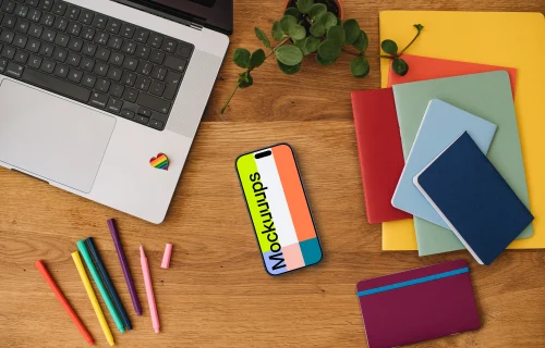 Smartphone mockup with rainbow pens and notebooks