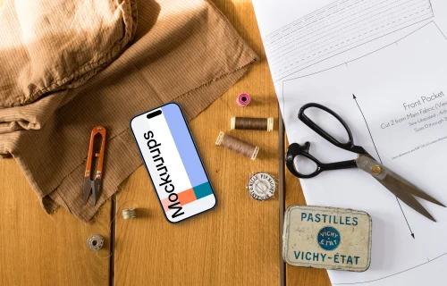 Top view of smartphone mockup with a sewing scissors