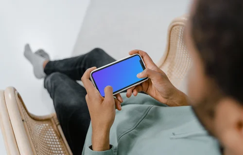 User holding iPhone in landscape mode mockup 