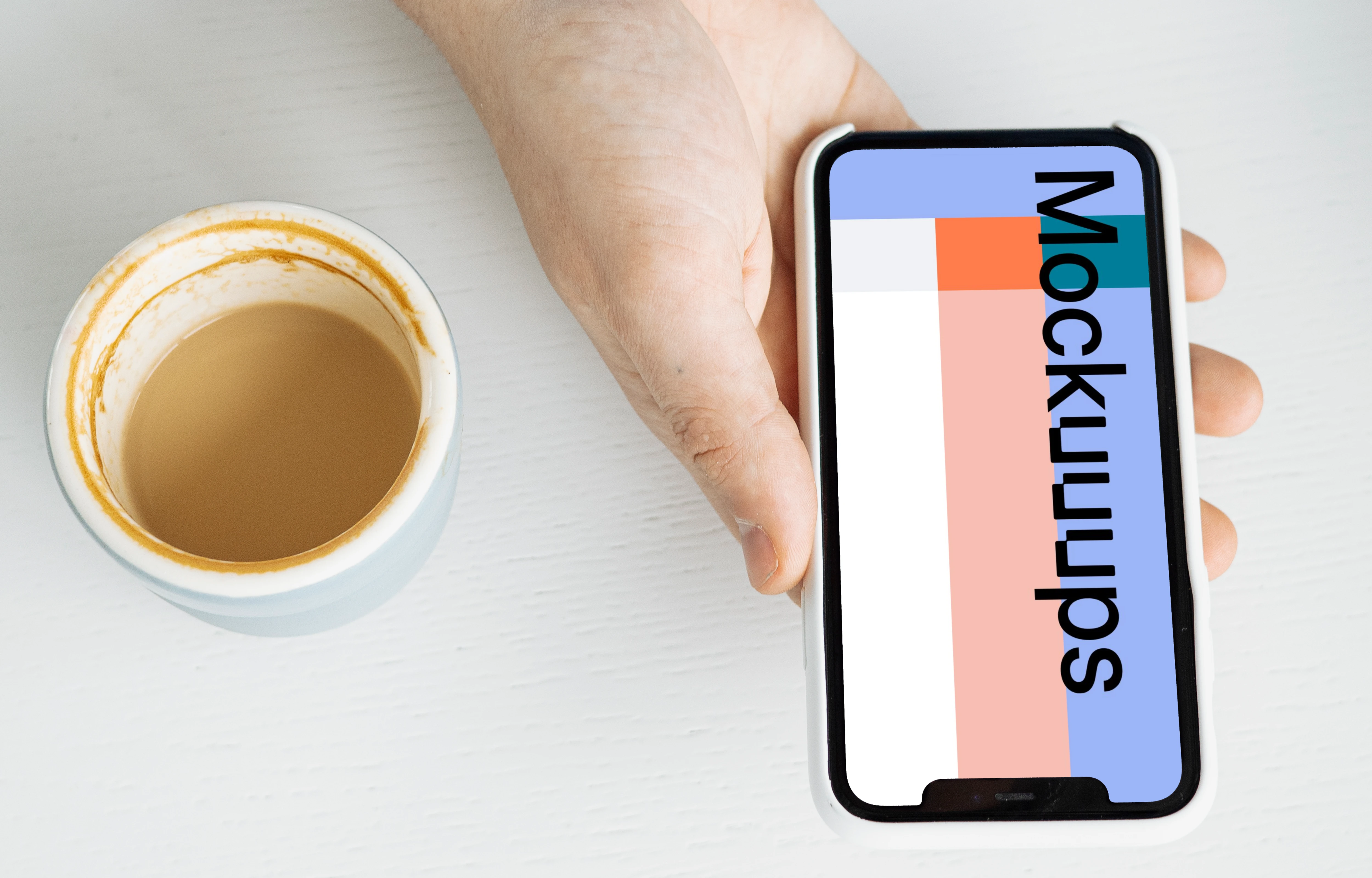 iPhone mockup in a user’s hand with a cup of coffee at the side