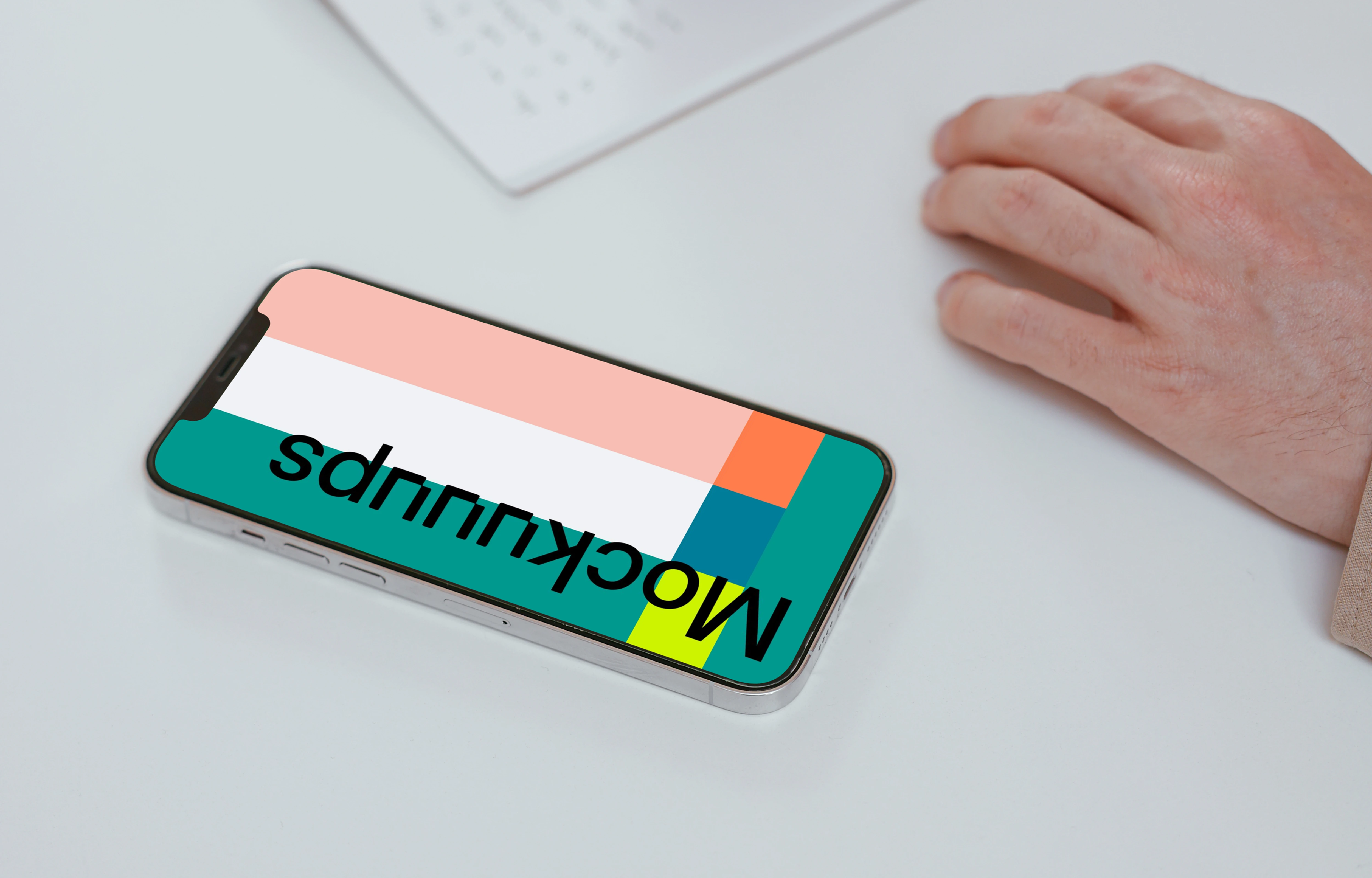 Simple iPhone mockup on a white table with a user writing by the side
