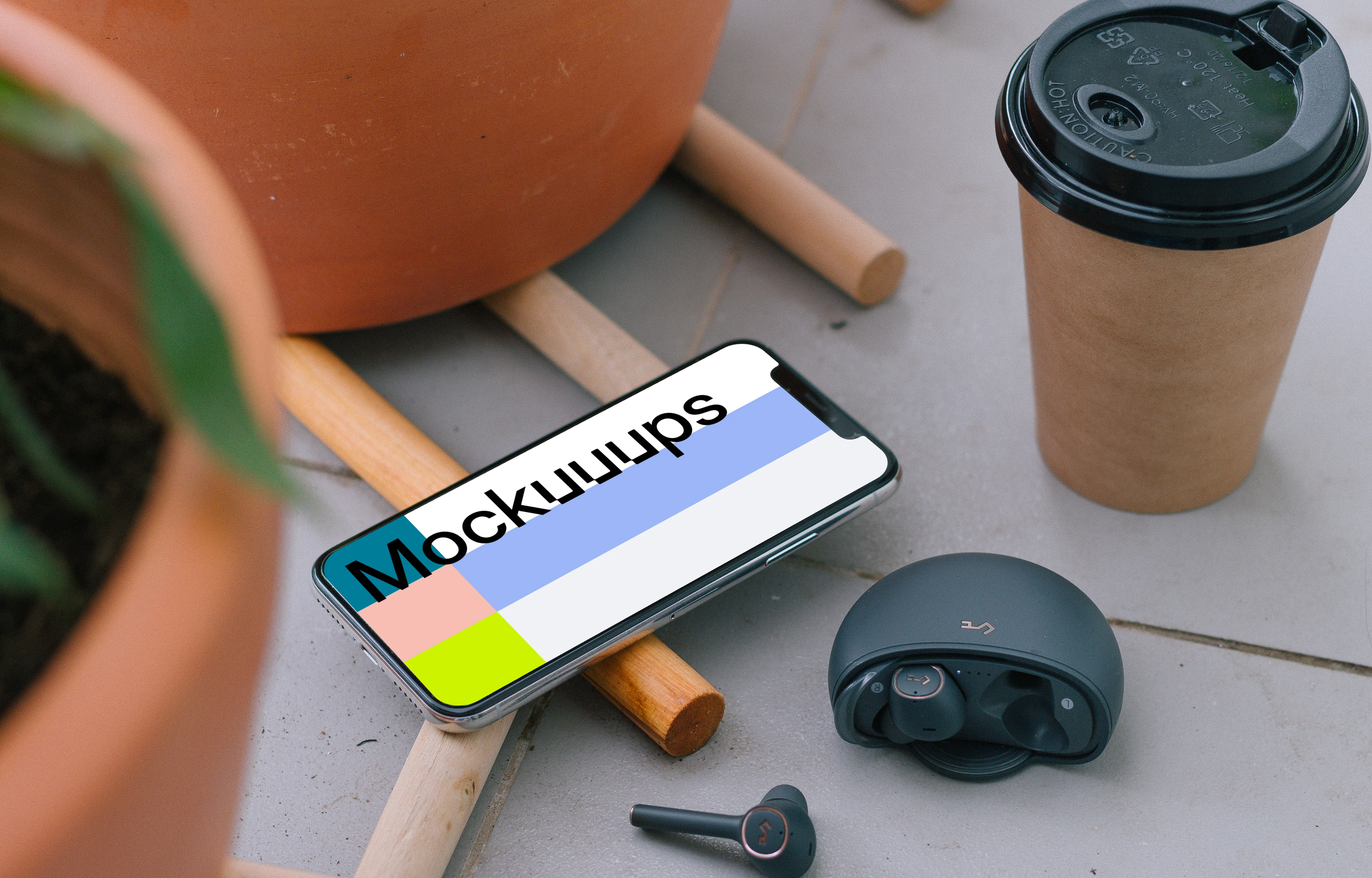  iPhone 12 mockup beside to a cup of coffee and earbuds