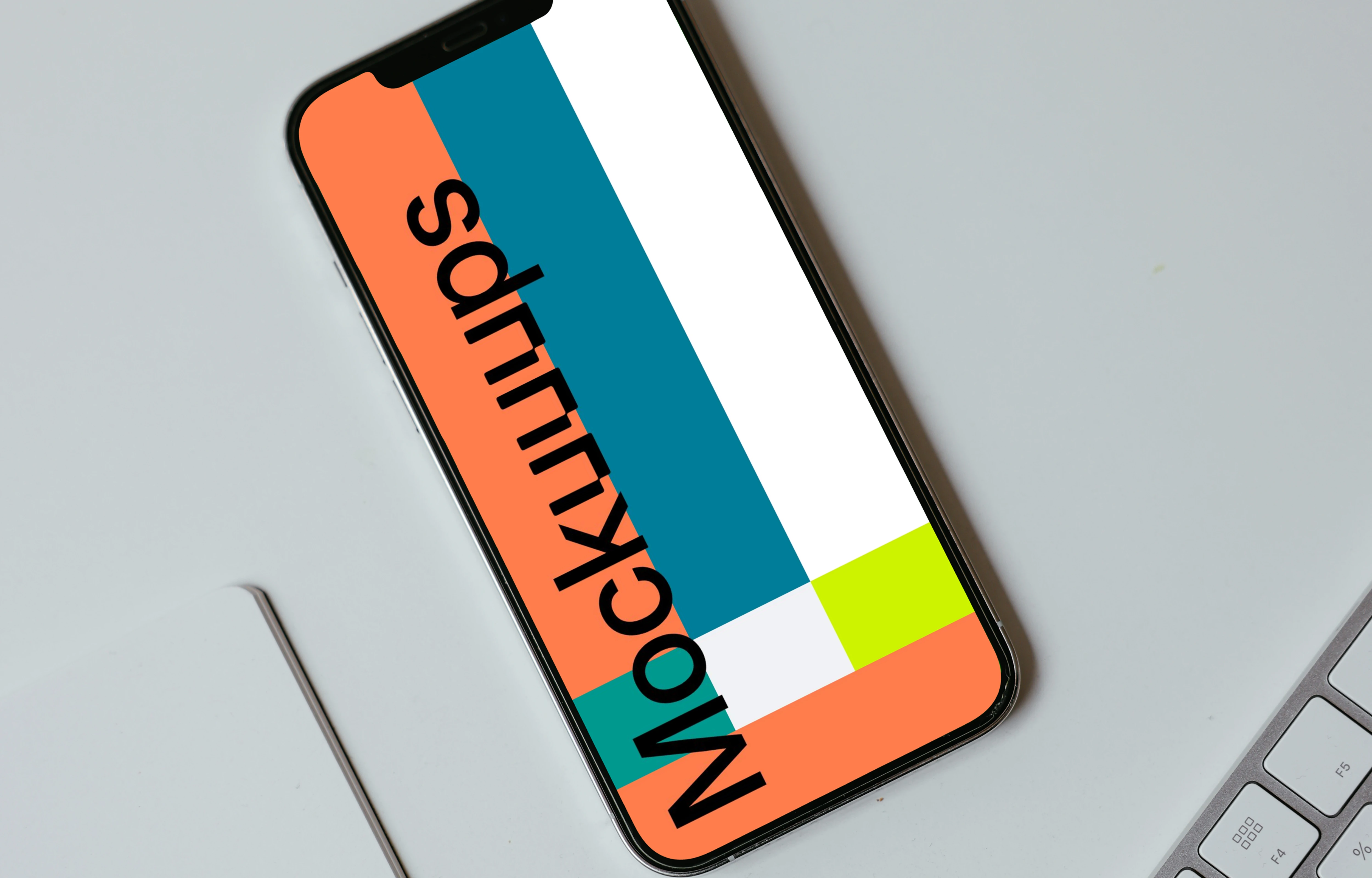 Minimal iPhone mockup on a white table with a wireless keyboard by the side