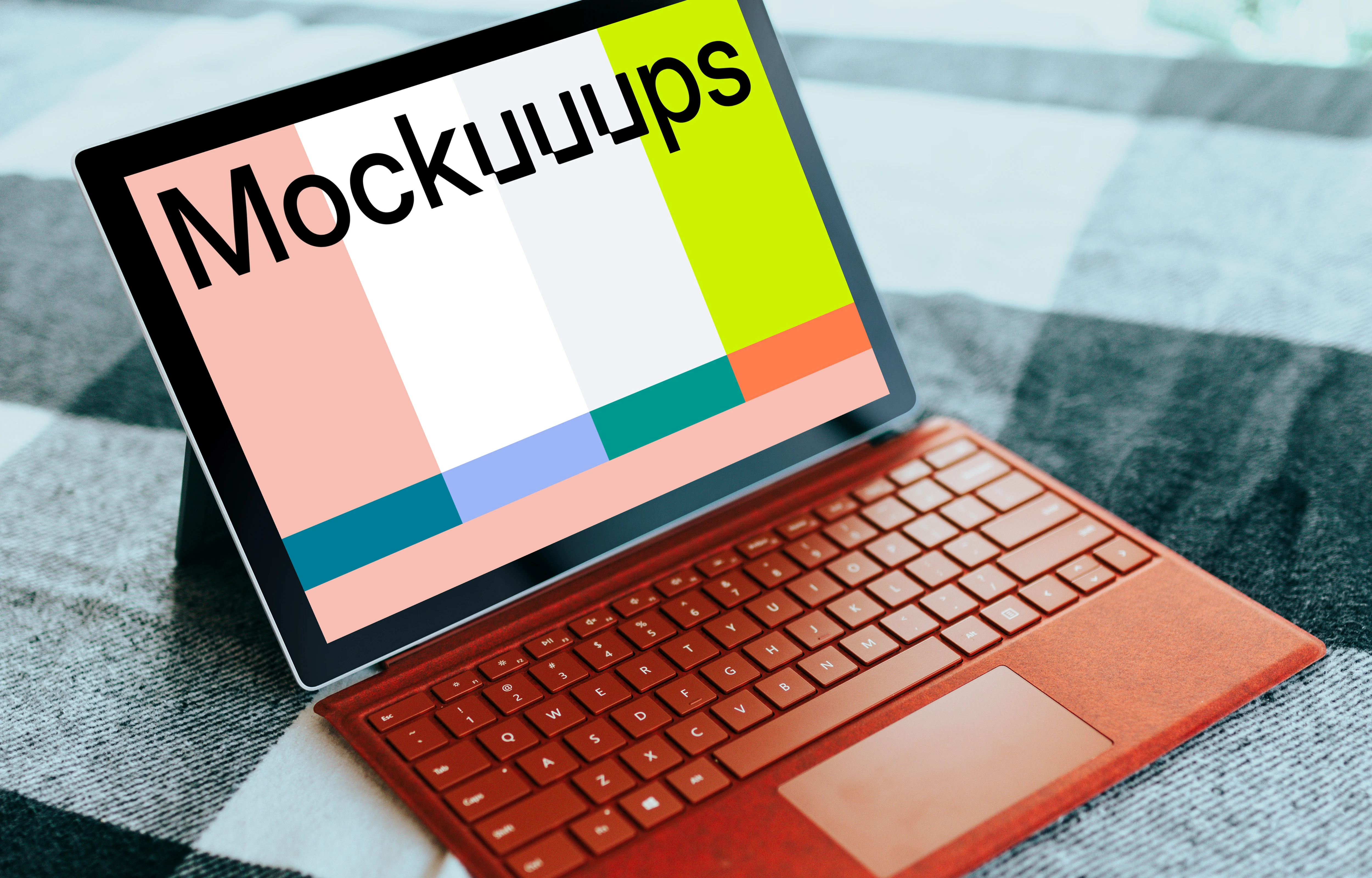 Red Microsoft Surface Laptop mockup on a bed