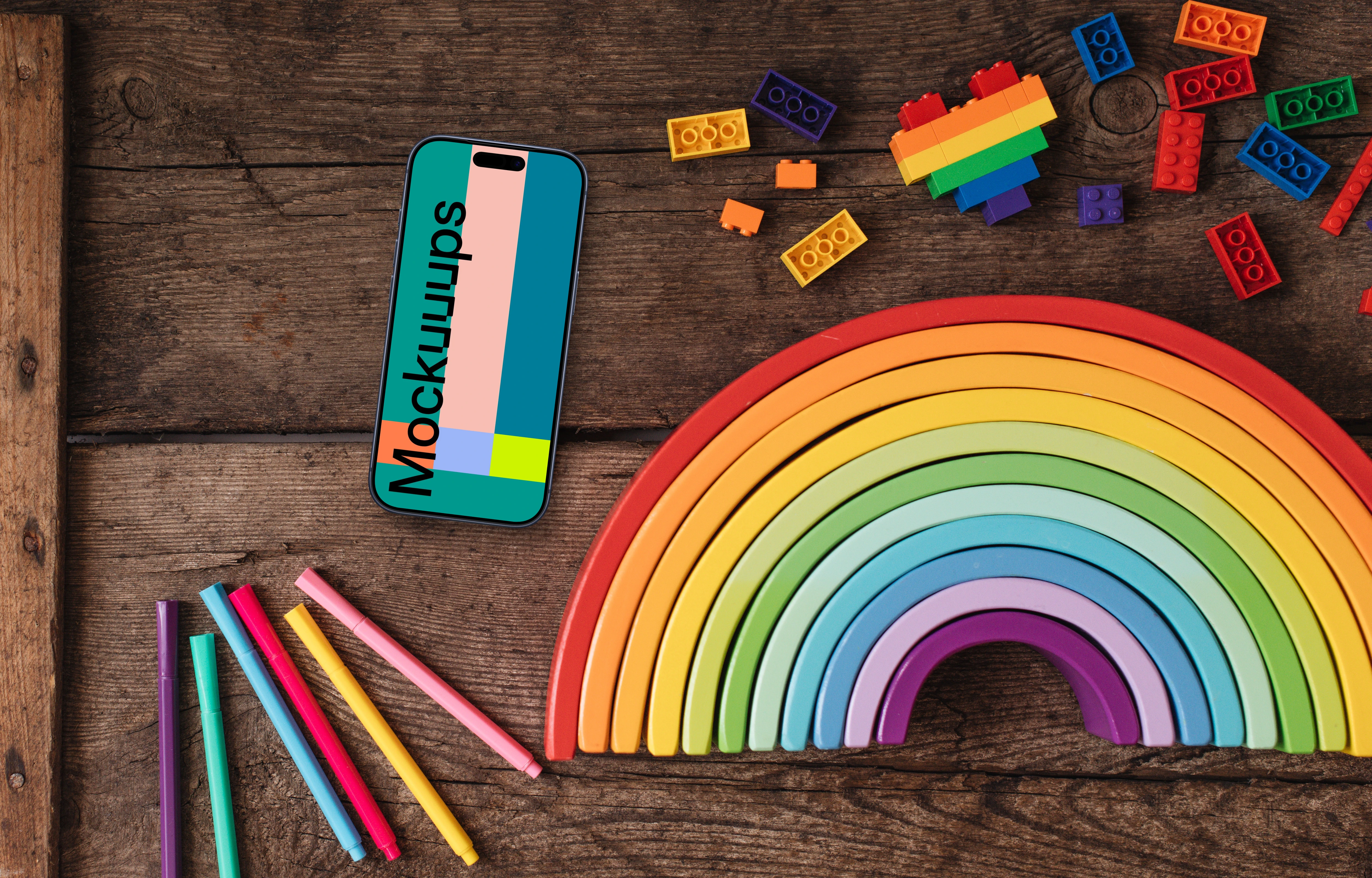 Smartphone mockup on a wooden table with rainbow items