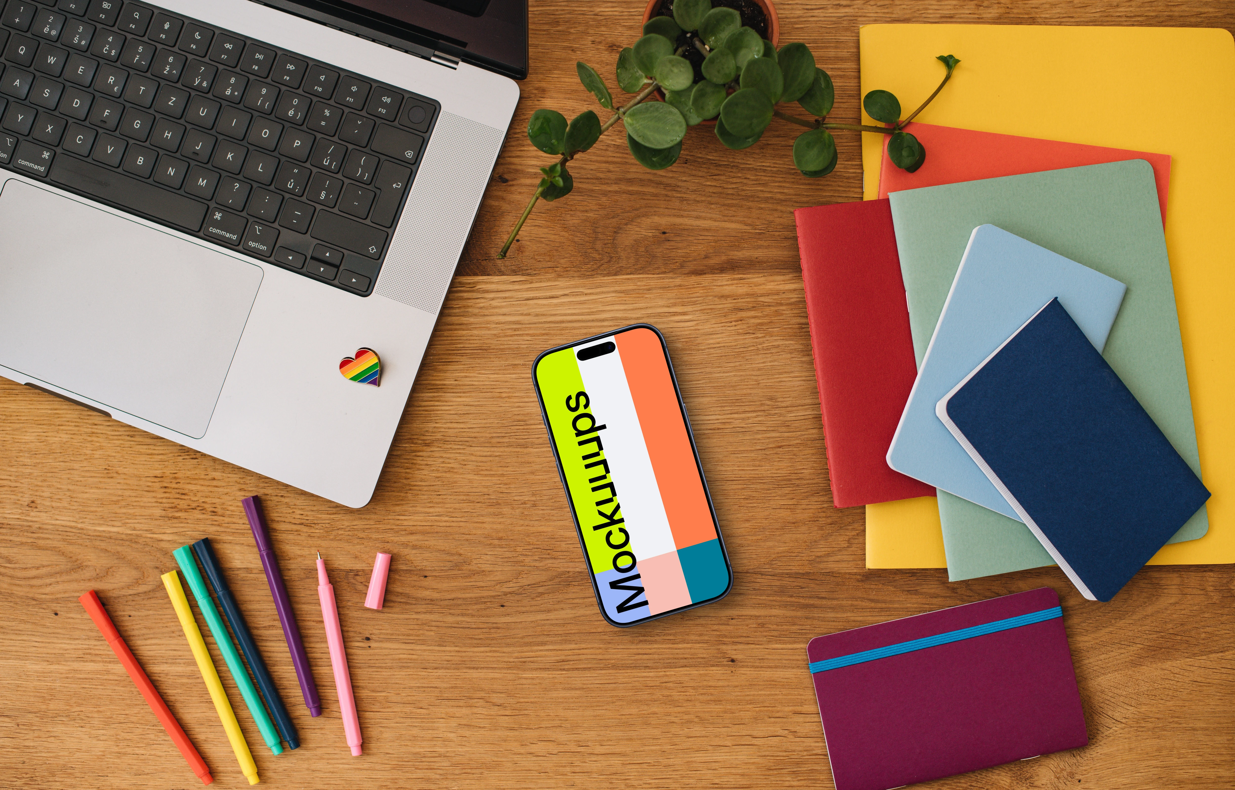 Smartphone mockup with rainbow pens and notebooks